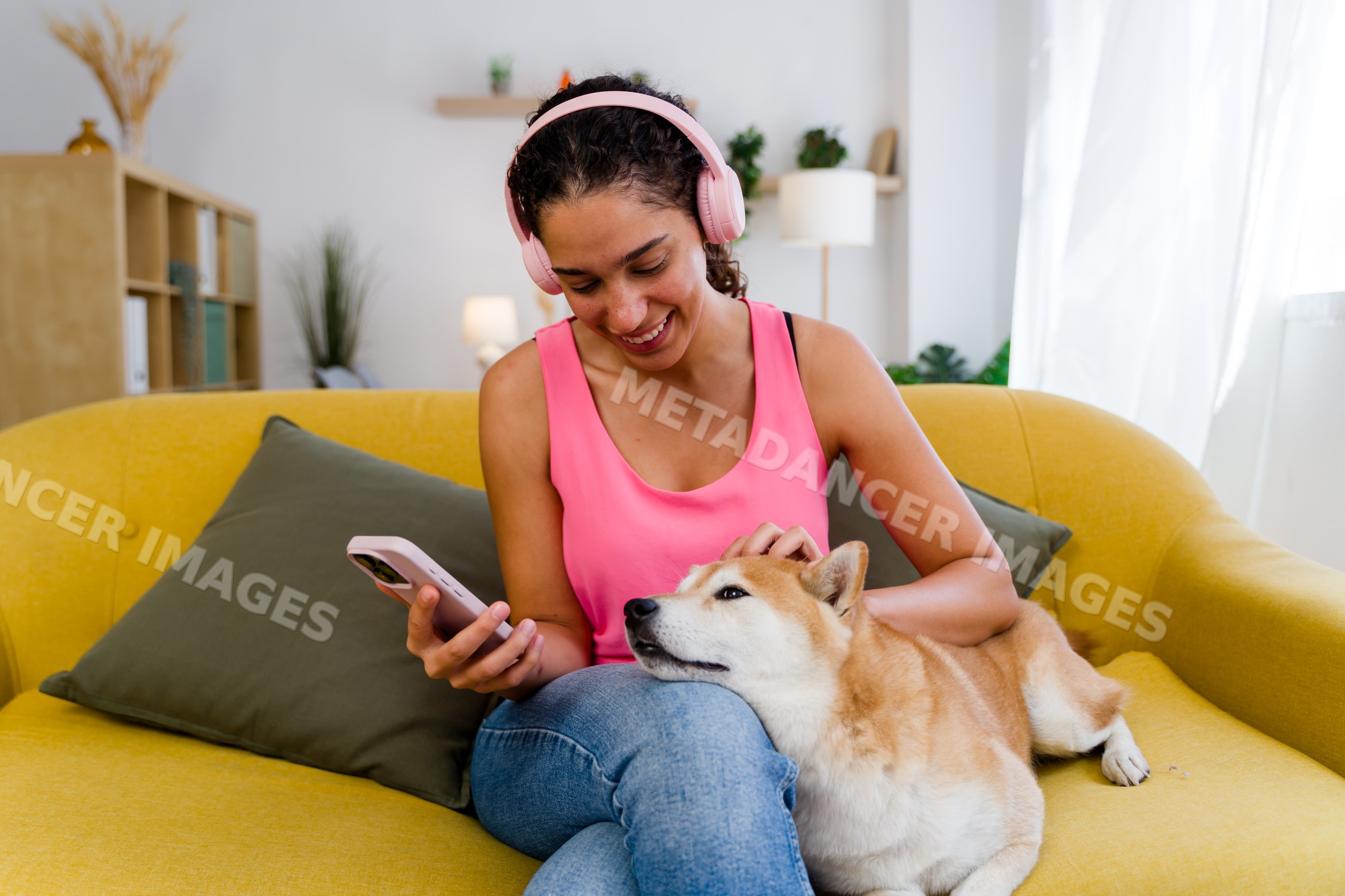 A Hispanic woman pets her dog