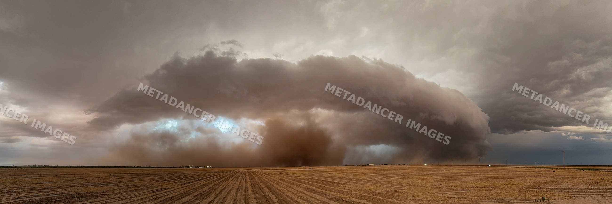 Supercell storm with dust cloud over farmland near garden city texas