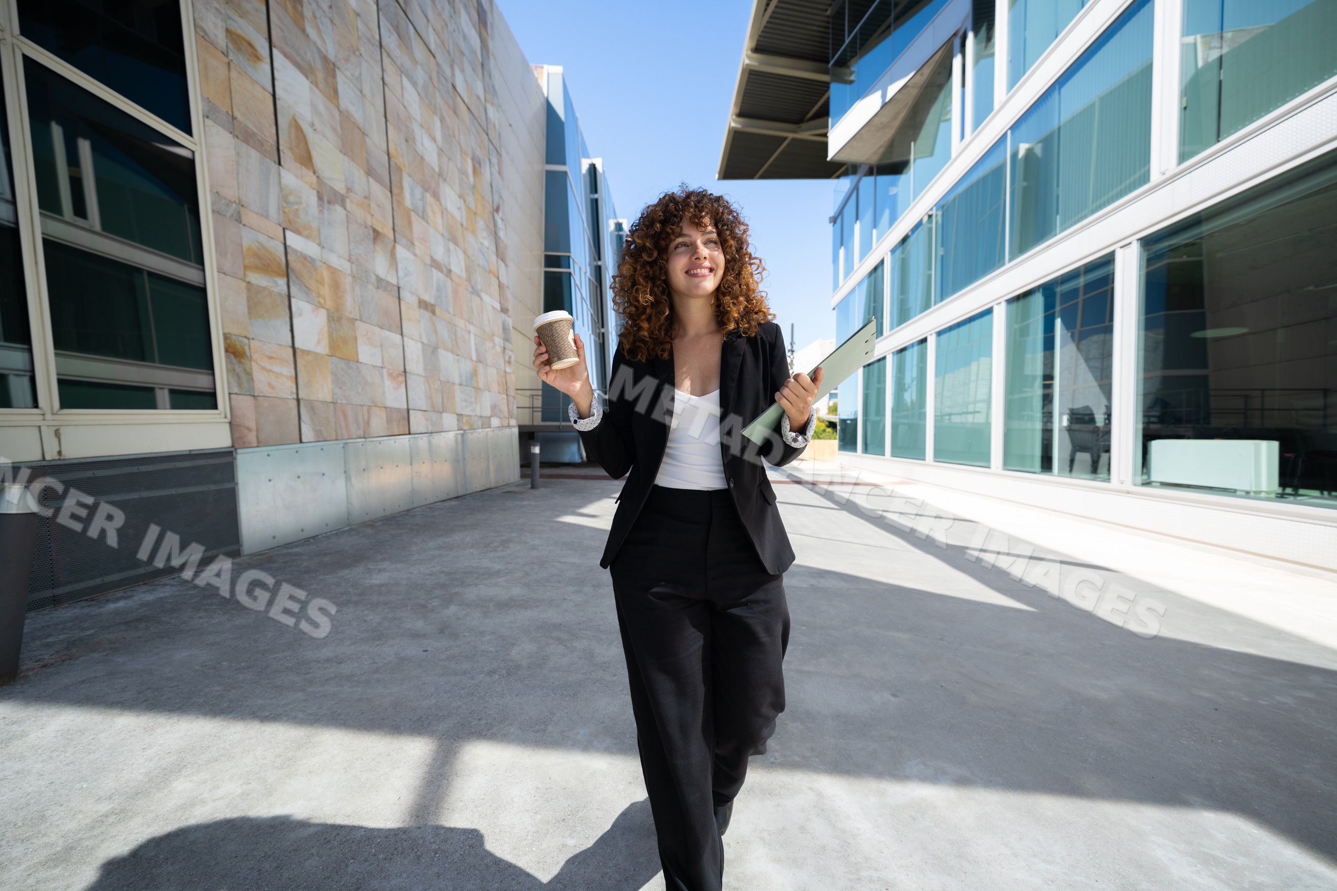 Businesswoman walking outside modern office buildings in a office