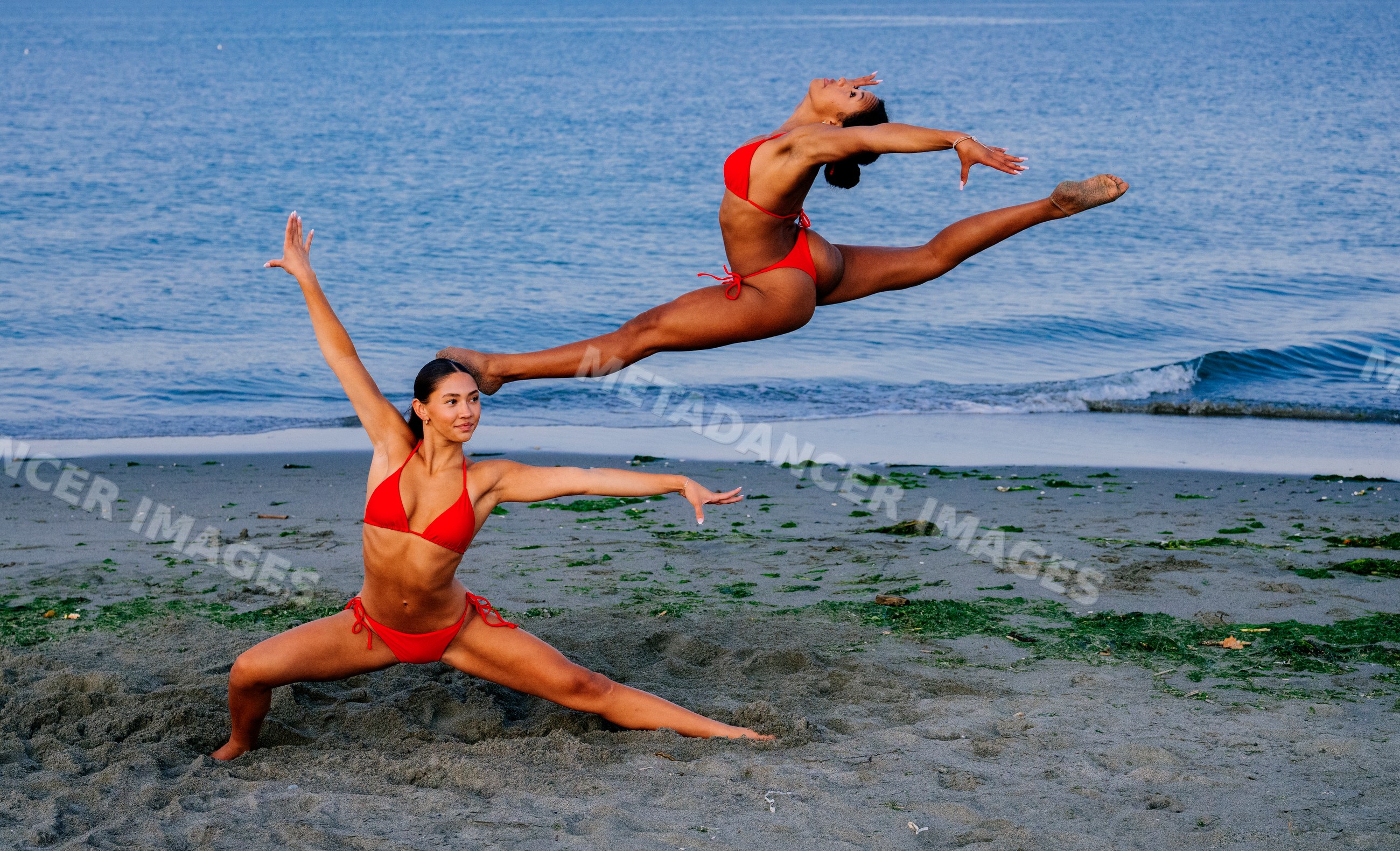 Two women perform partner acrobatics Yoga on a beach in WA, USA