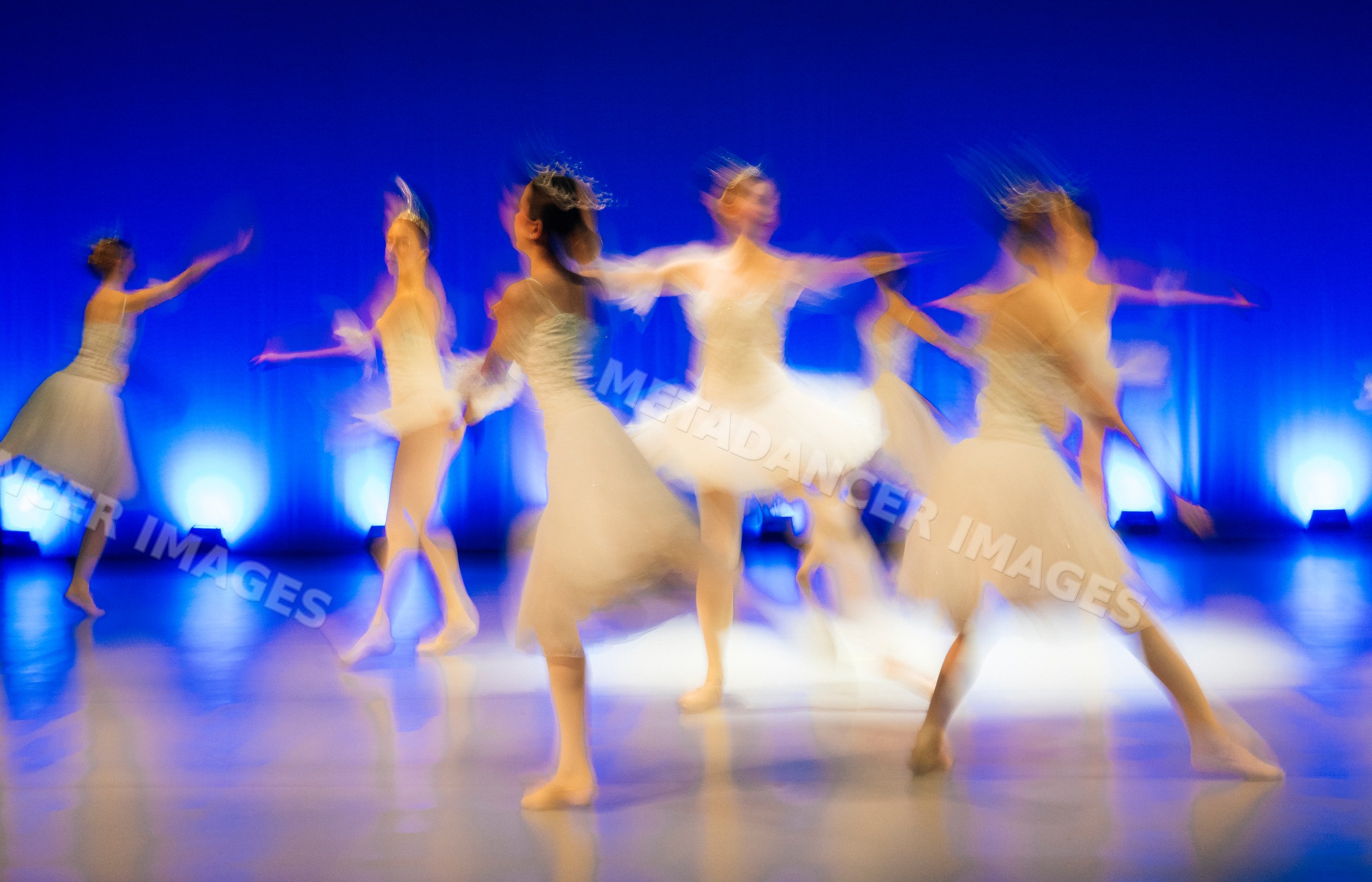 Ballet dancers perform holiday ballet on stage in white tutus