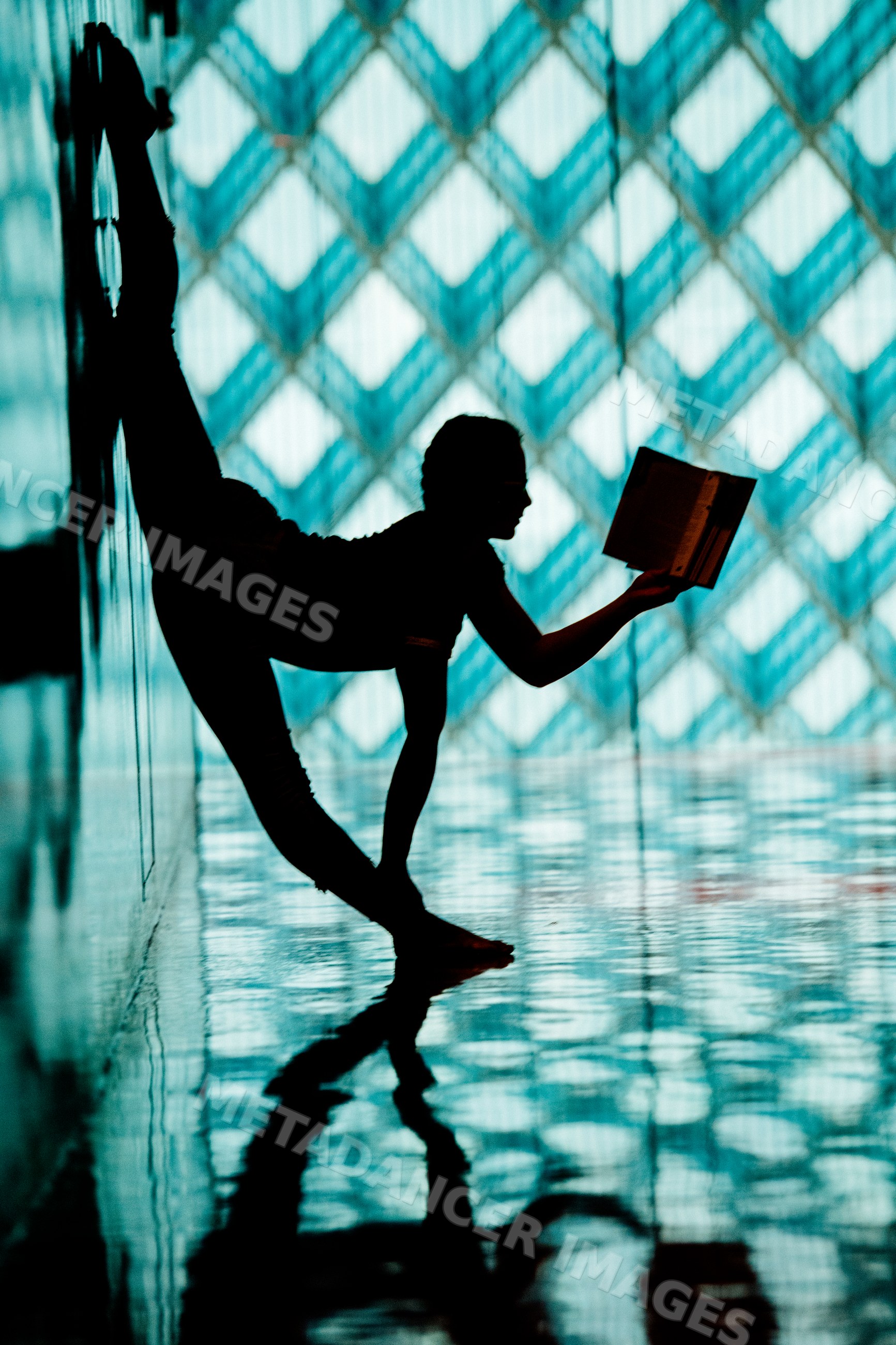 A woman stretching in a yoga pose while reading in a library