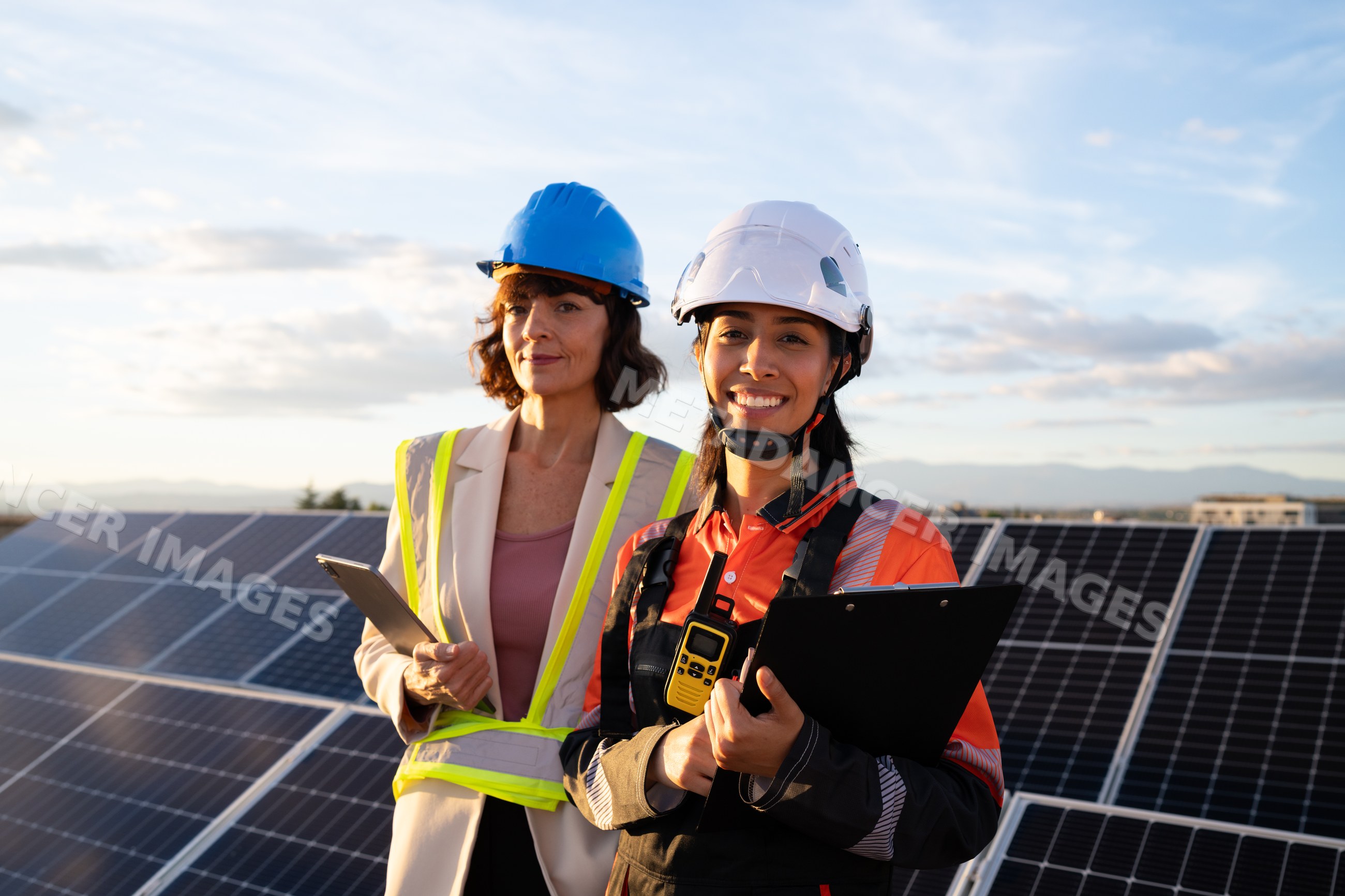 Two Hispanic and white women engineers inspecting solar panels