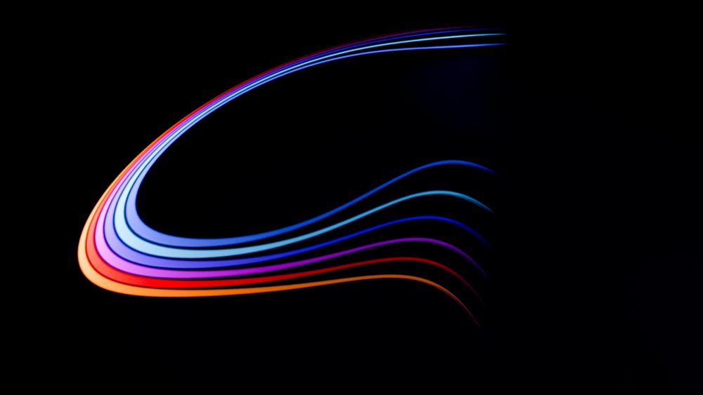 Abstract colorful curved light streaks on dark background