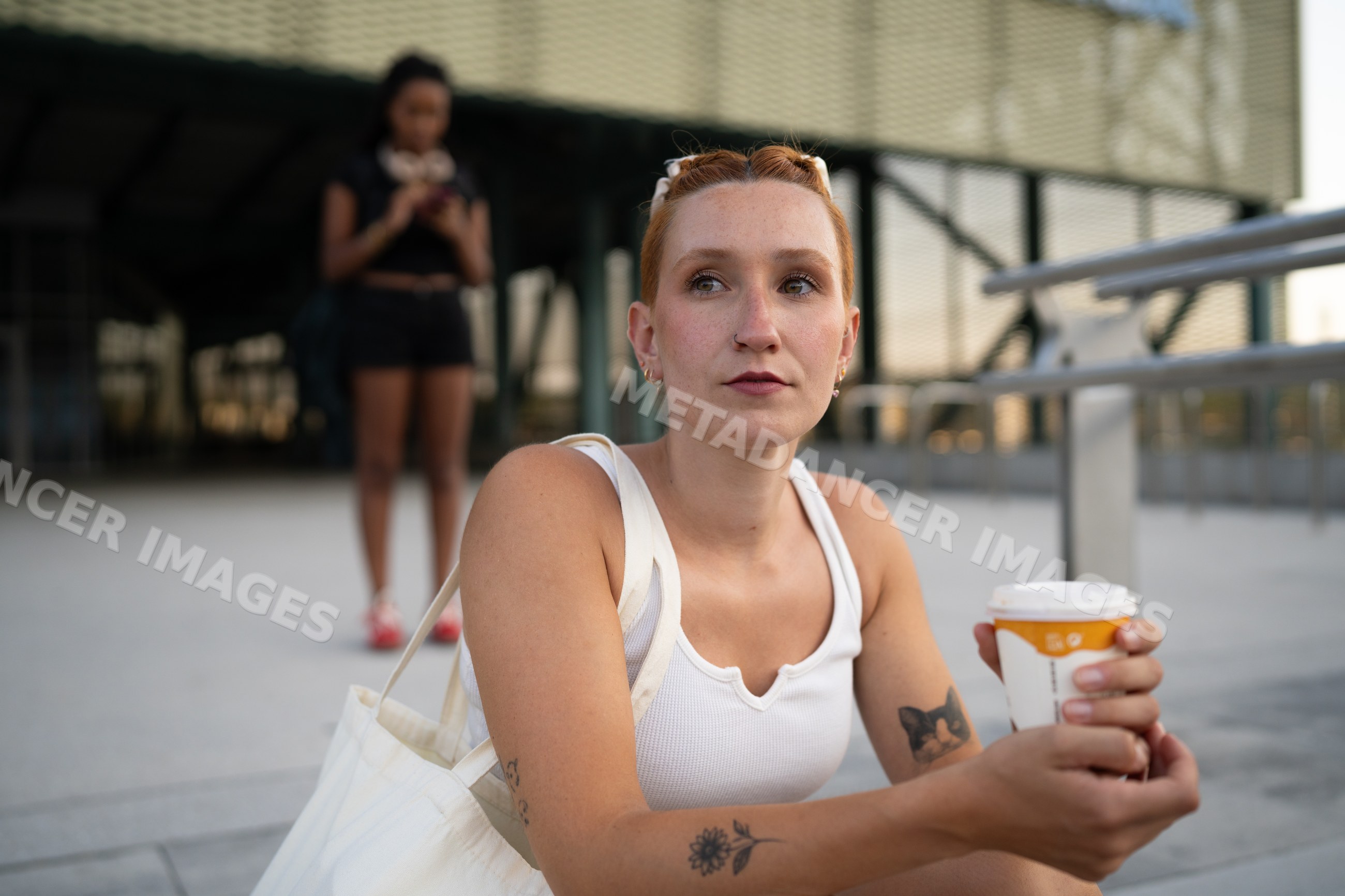 A young white woman sits outdoors holding a coffee cup in Santiago