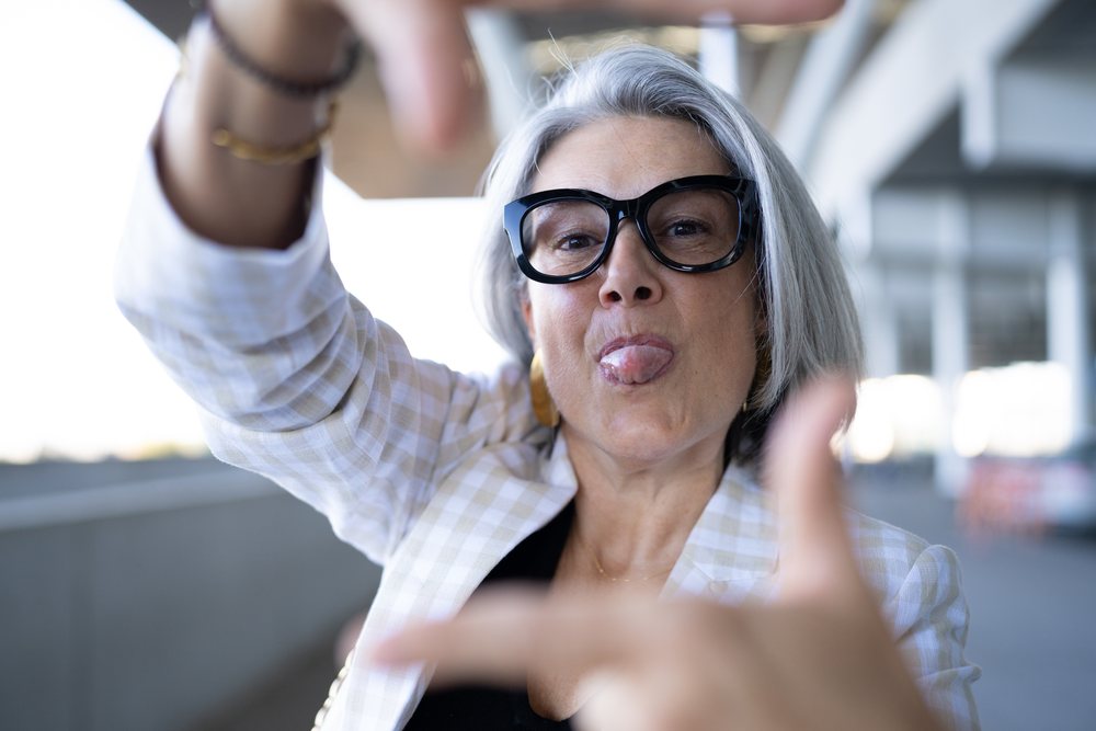 Middle-aged white woman making a framing gesture with humorous