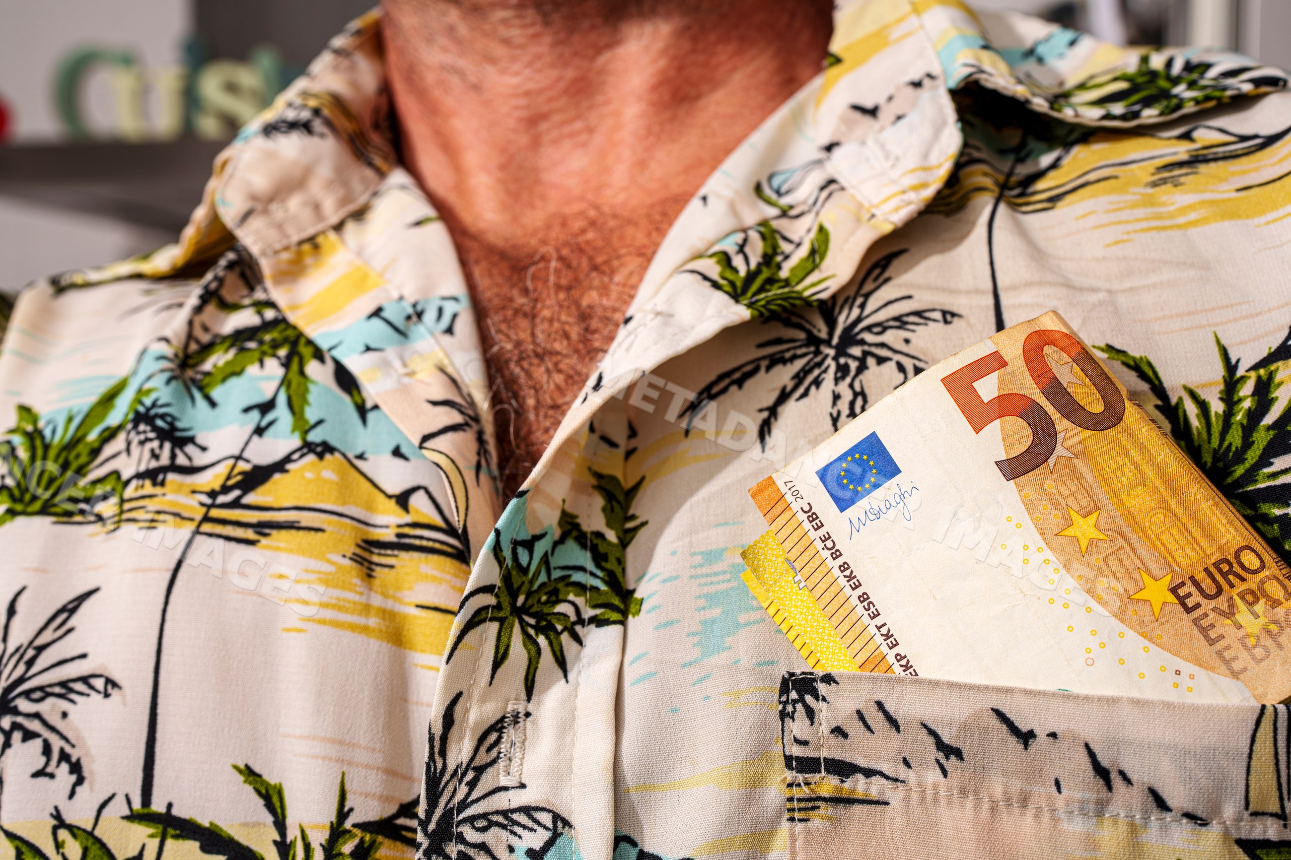 50 euro banknotes tucked in tropical print shirt pocket