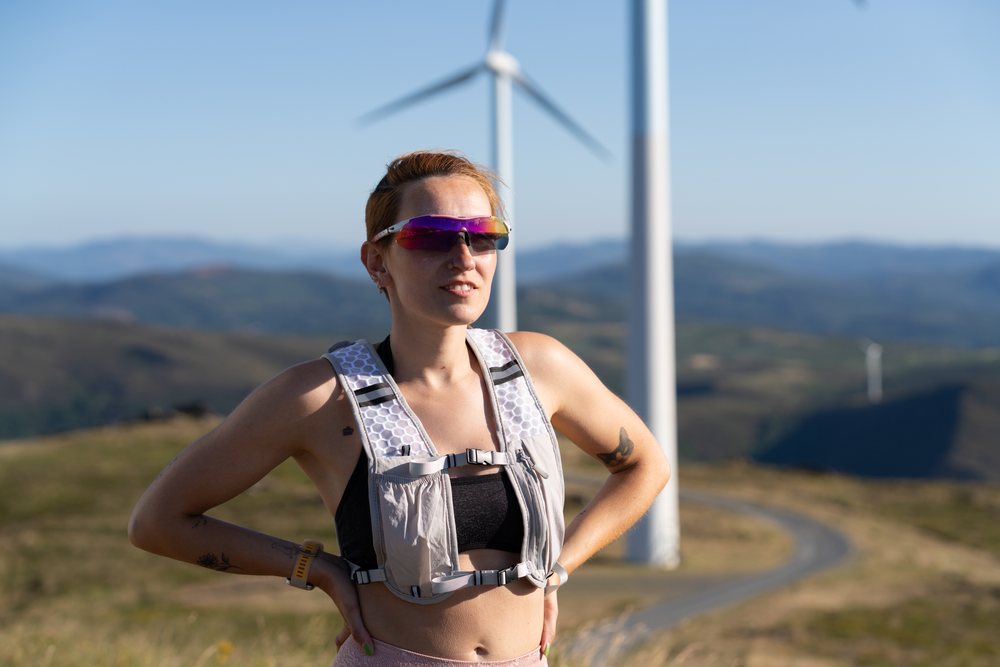 White Woman runner wearing hydration vest on mountain trail