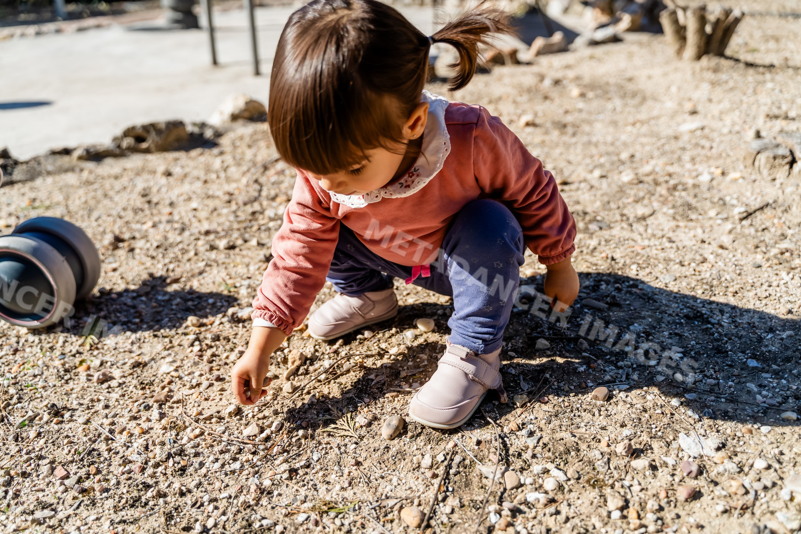 Toddler playing and picking rocks outdoors