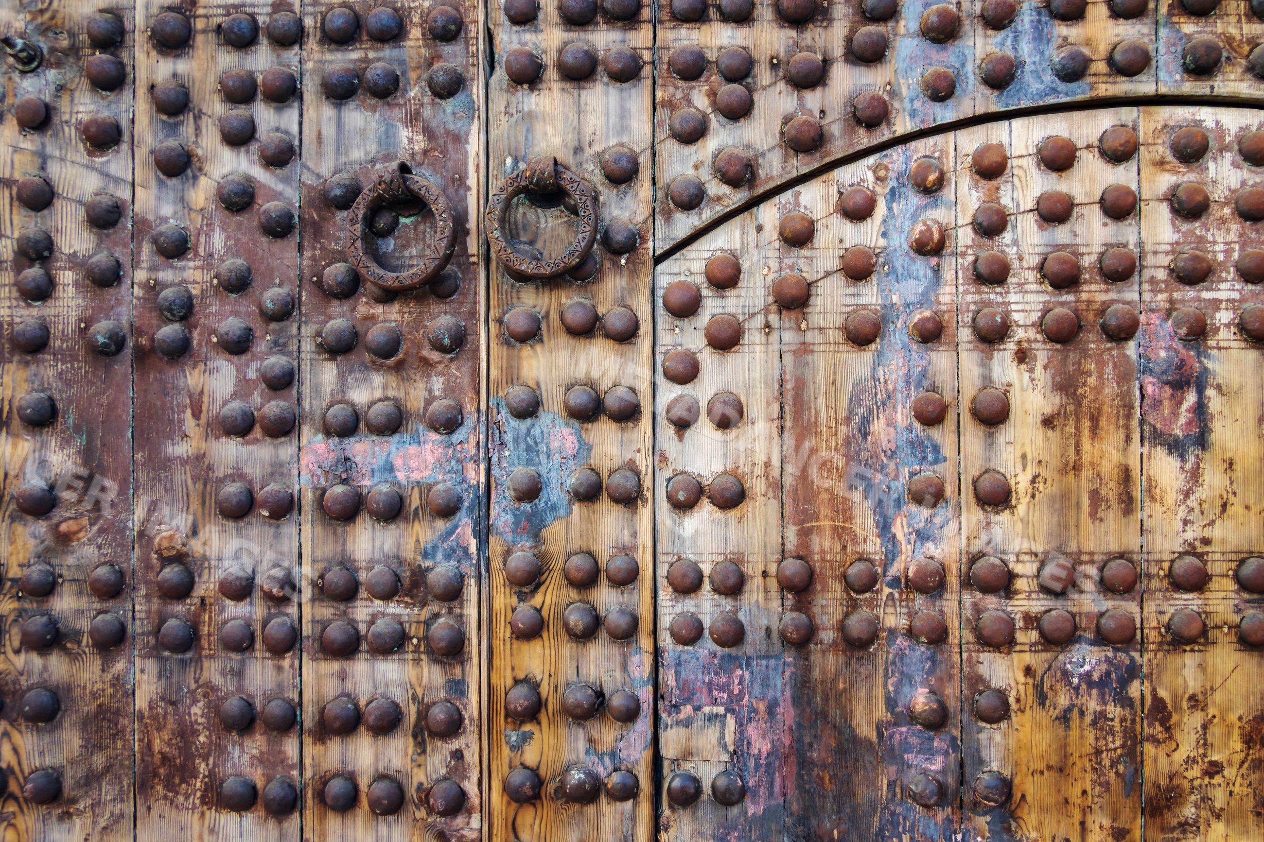 Ancient wooden door with ornate metal studs in marrakech Morocco