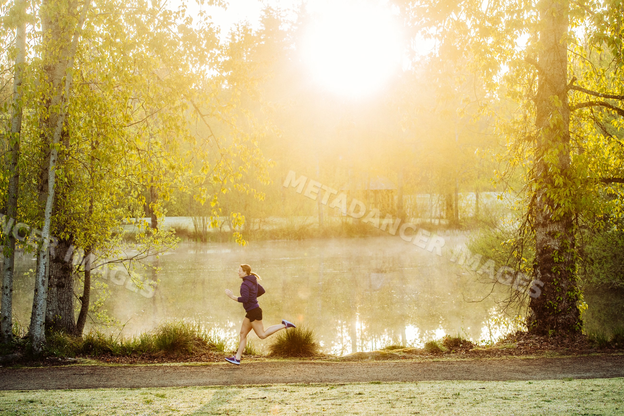 White runner jogging in morning park with sunlight and mist