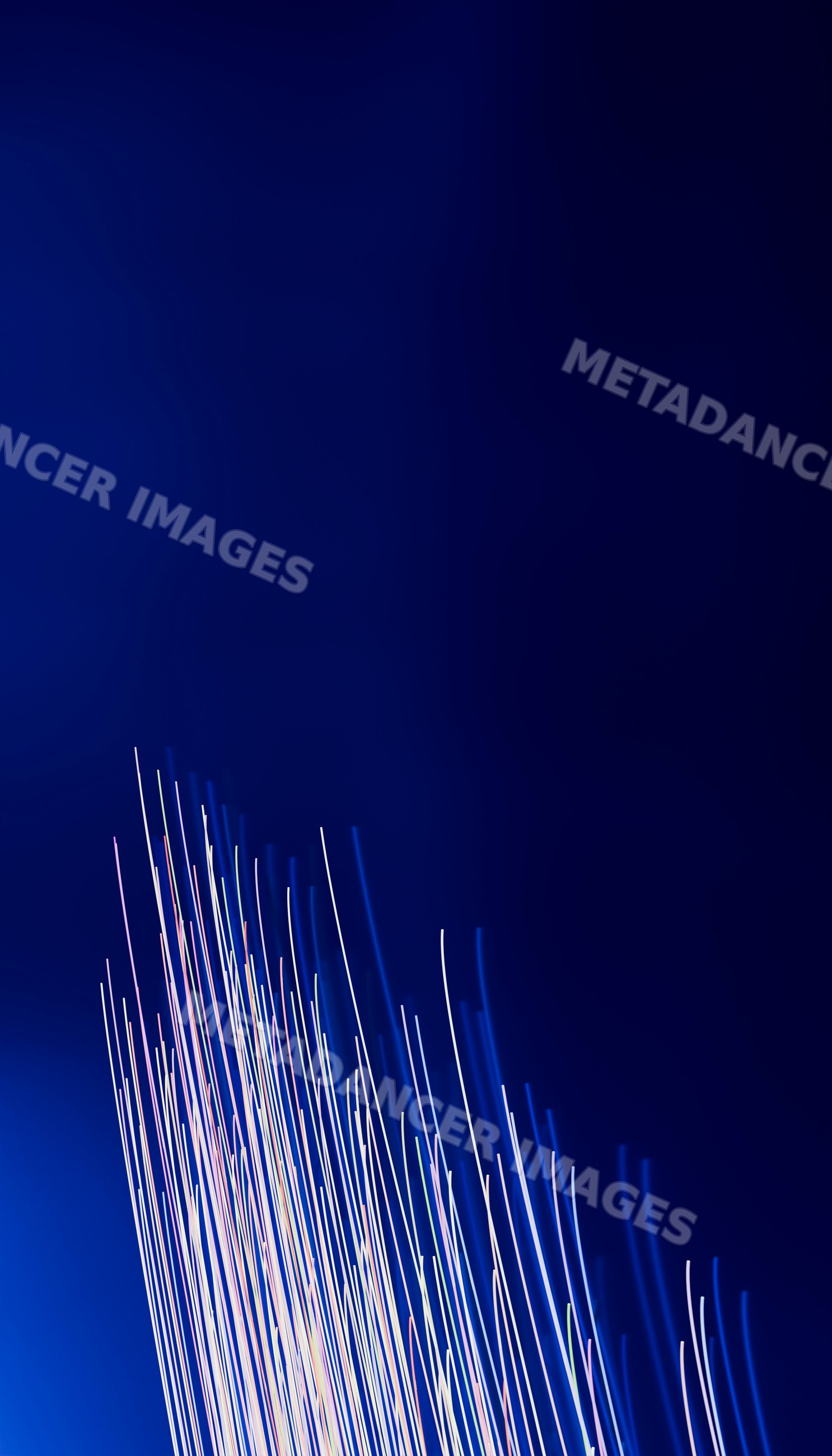 Abstract light trails streaking upward on dark blue background
