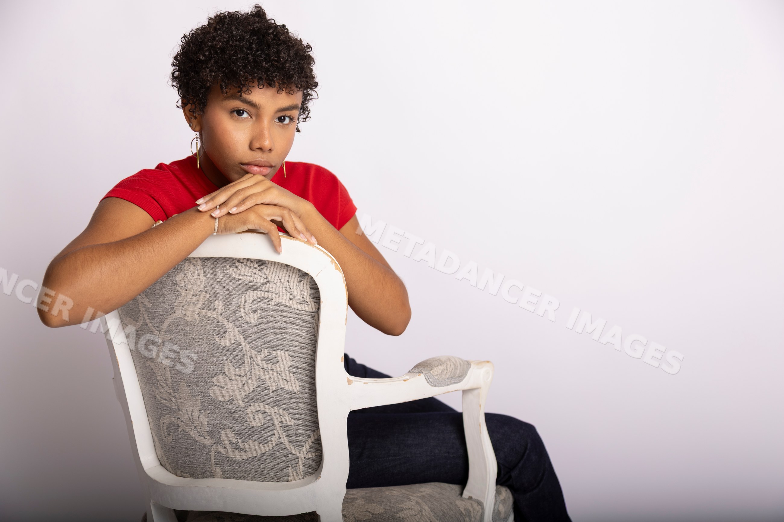 Young Hispanic woman sitting on patterned armchair