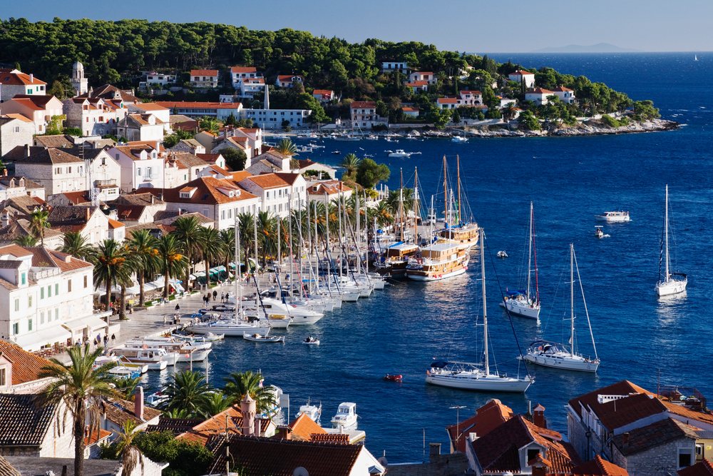 Coastal harbor with sailboats and red-roof houses, croatia