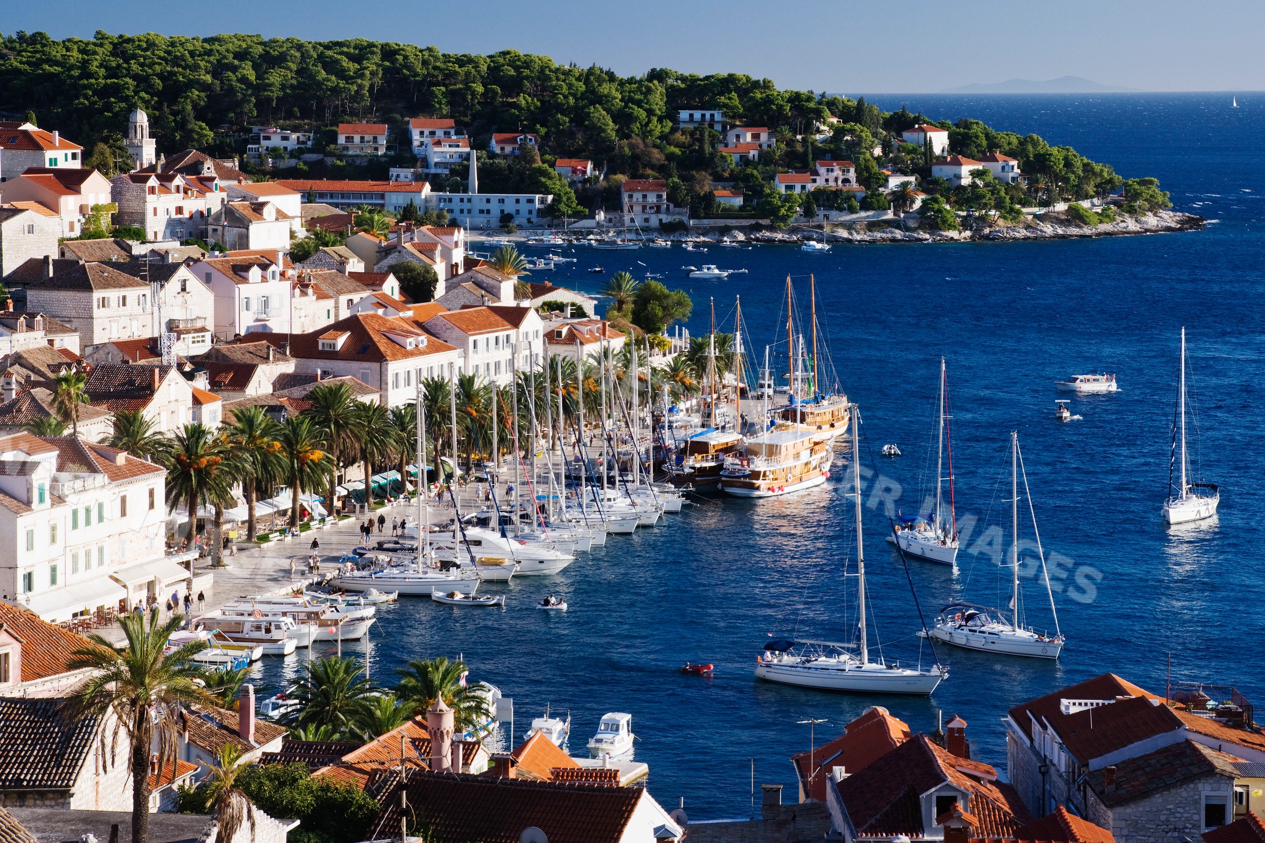 Coastal harbor with sailboats and red-roof houses, croatia