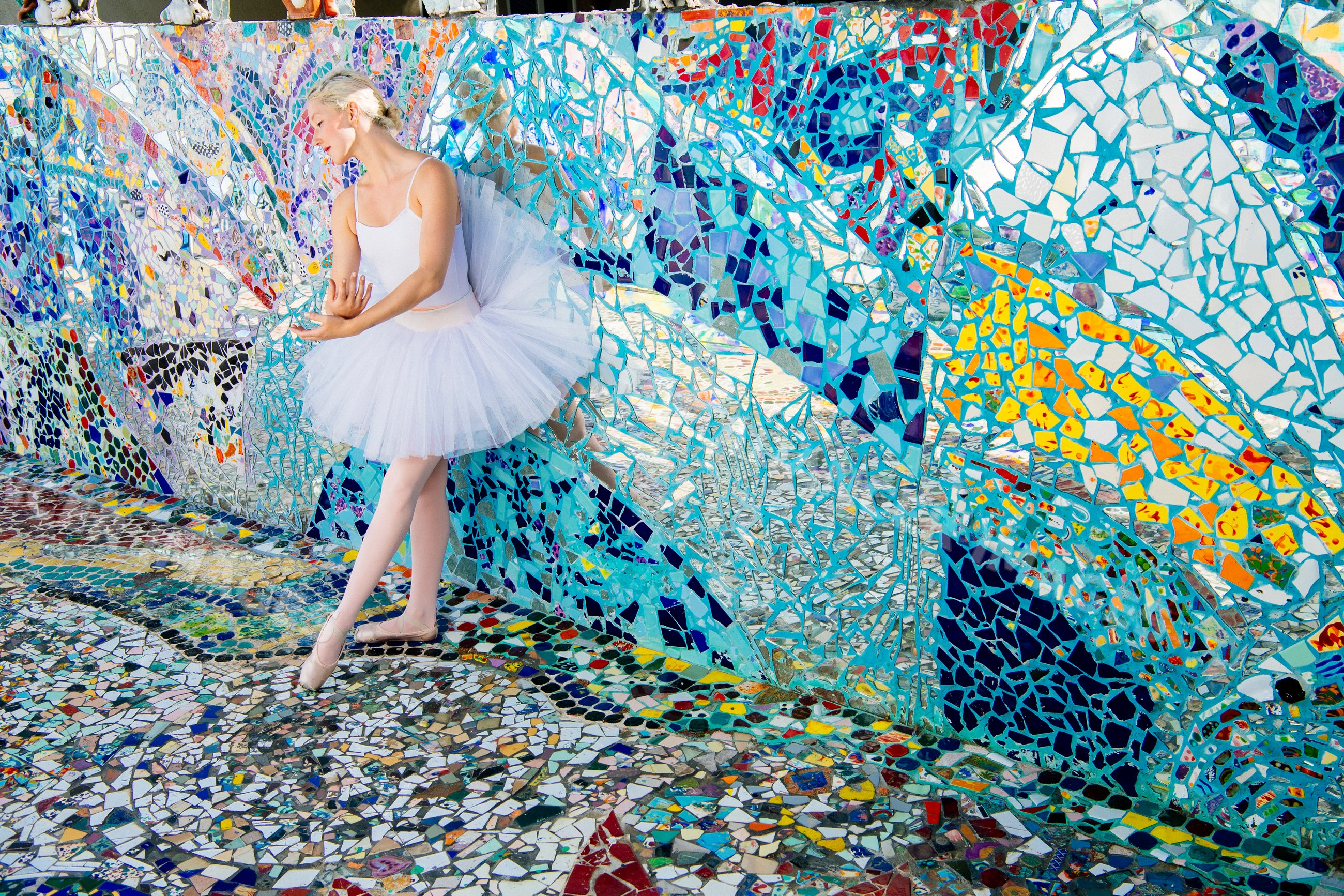 Ballerina dancing with colorful mosaic wall in CA, USA