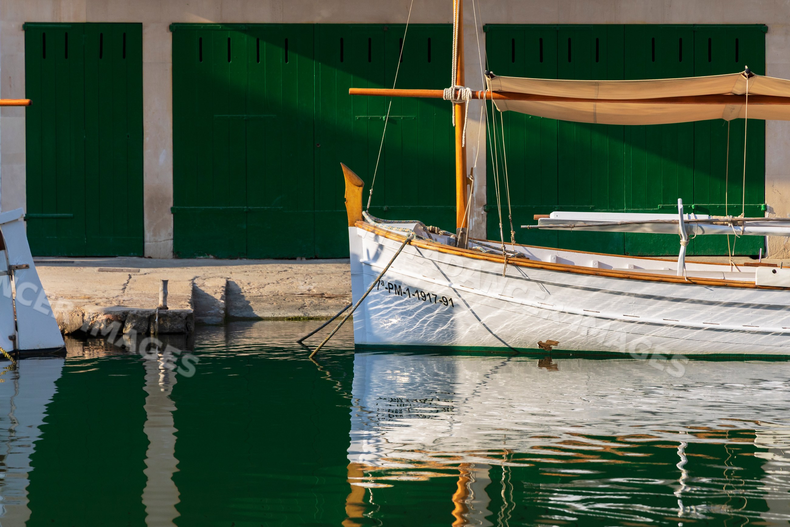 Wooden llaüts boats with white hulls moored in cala figuera harbor