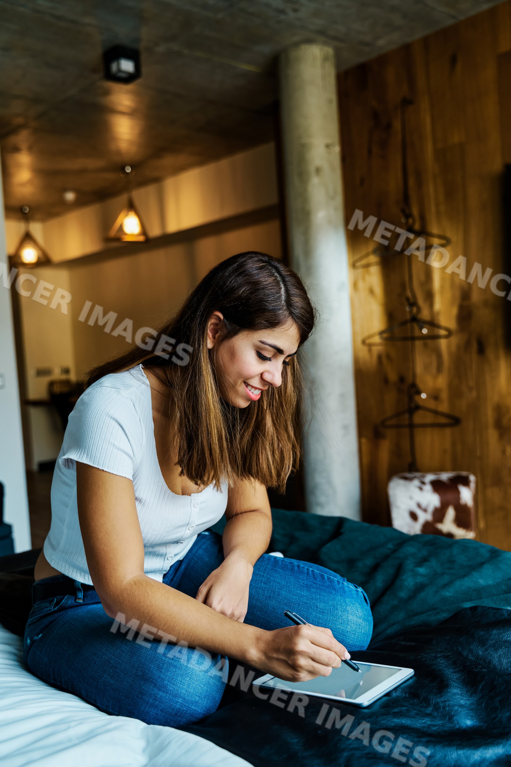 A young woman writing on a tablet in a hotel room in a hotel