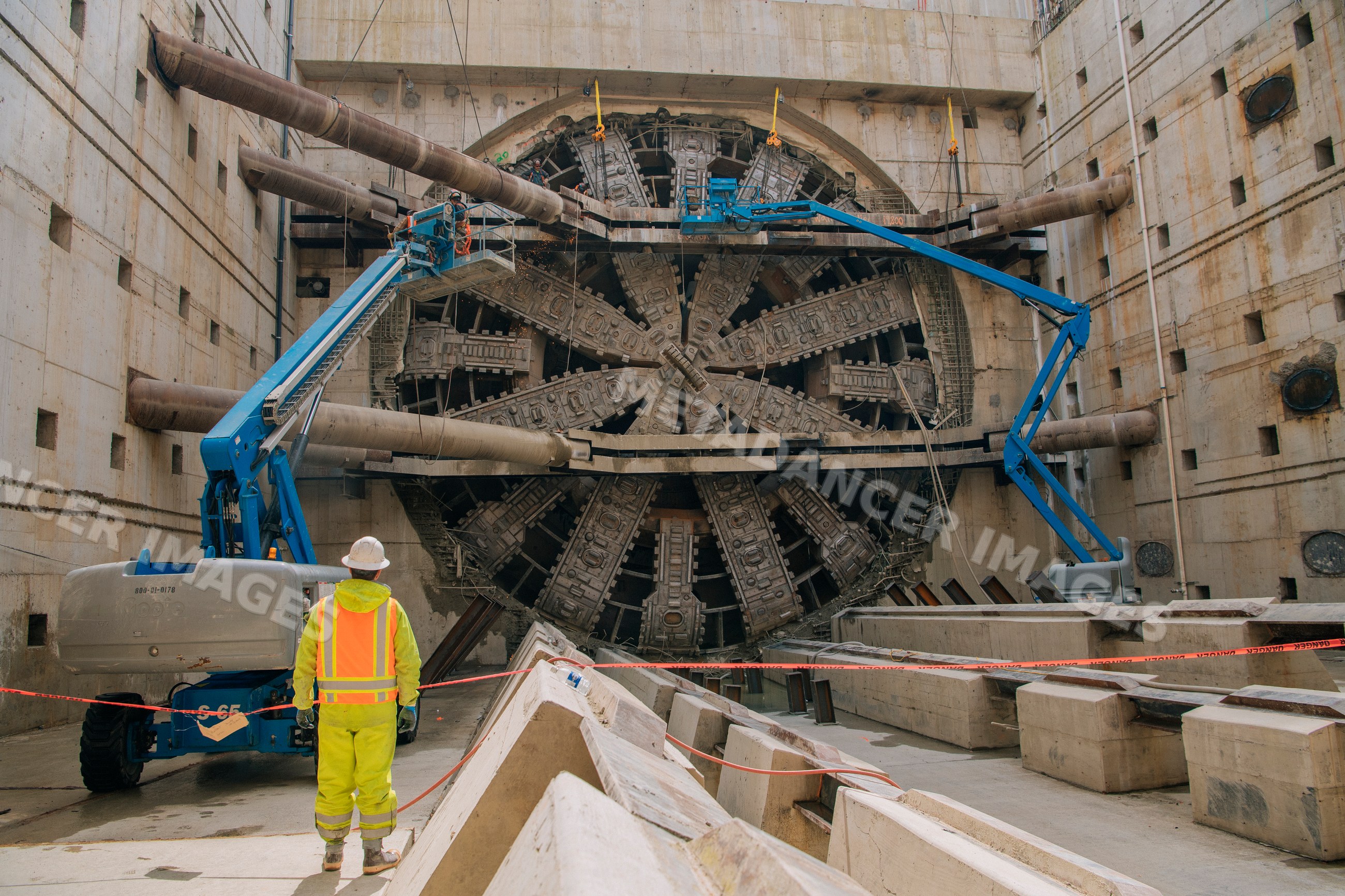 A construction white worker inspects a tunnel boring machine
