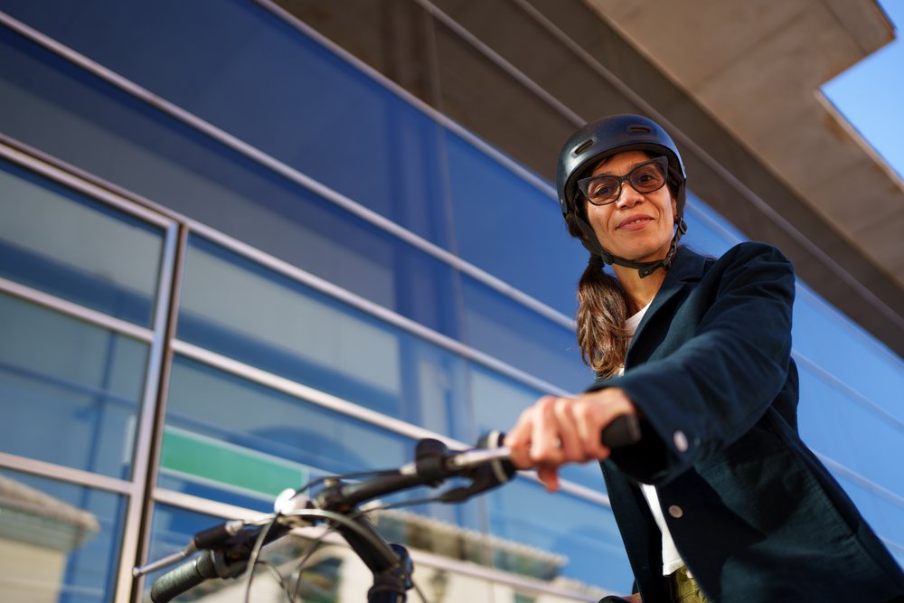 Hispanic woman with helmet riding bike outdoors