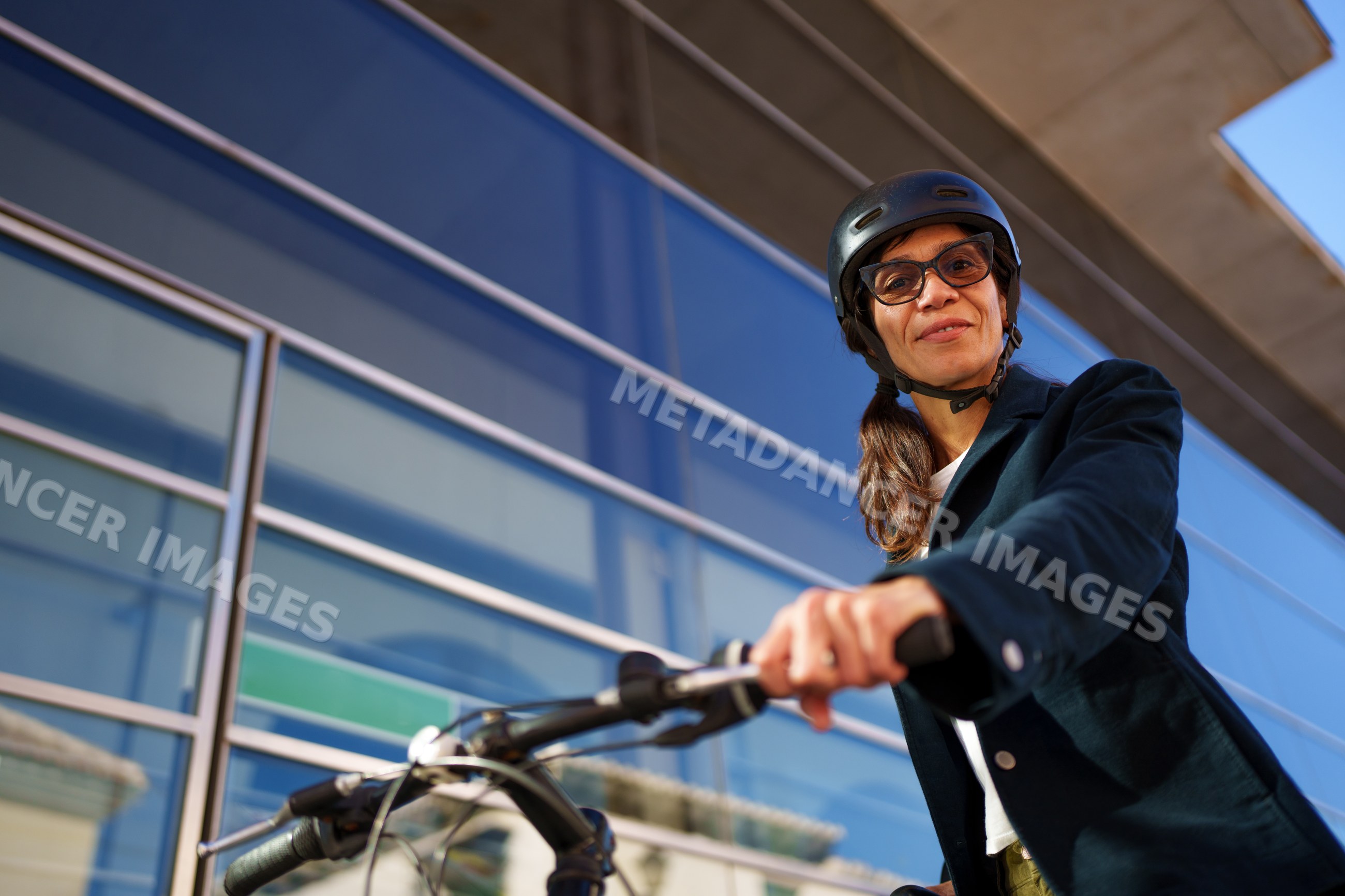 Hispanic woman with helmet riding bike outdoors