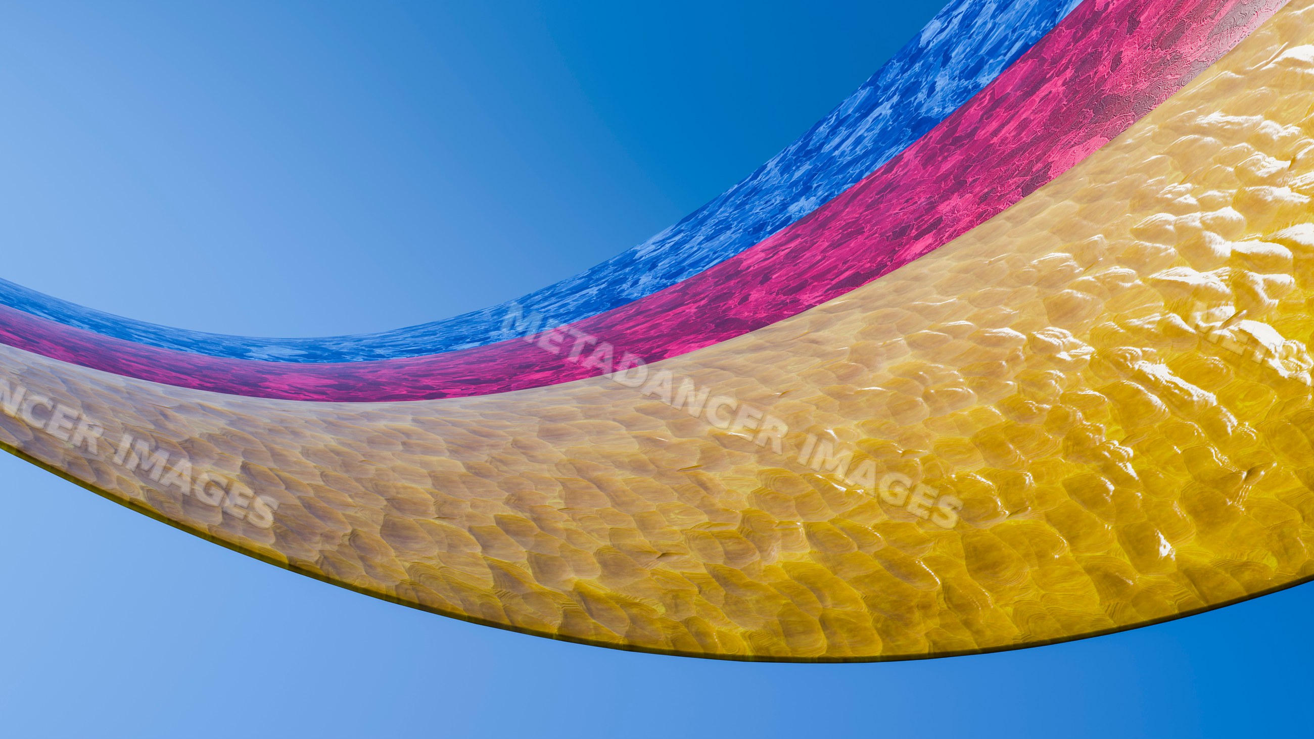 Colorful curved water sheets flowing against blue sky