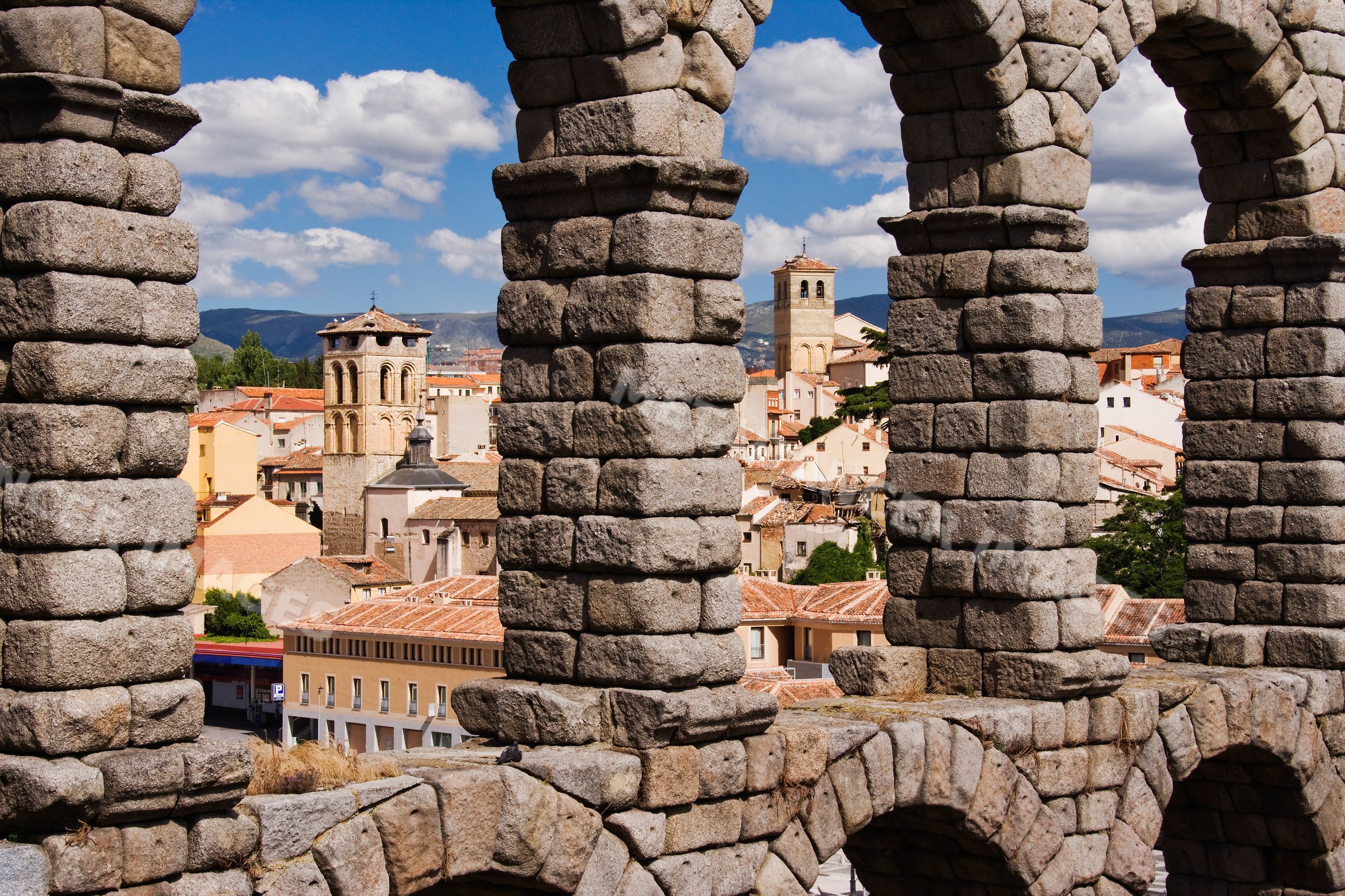 Roman aqueduct arches framing segovia cityscape