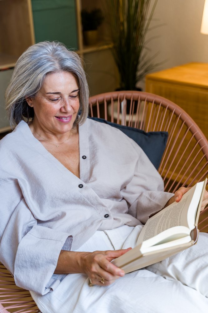 White woman reading book indoors in relaxed home setting in a home