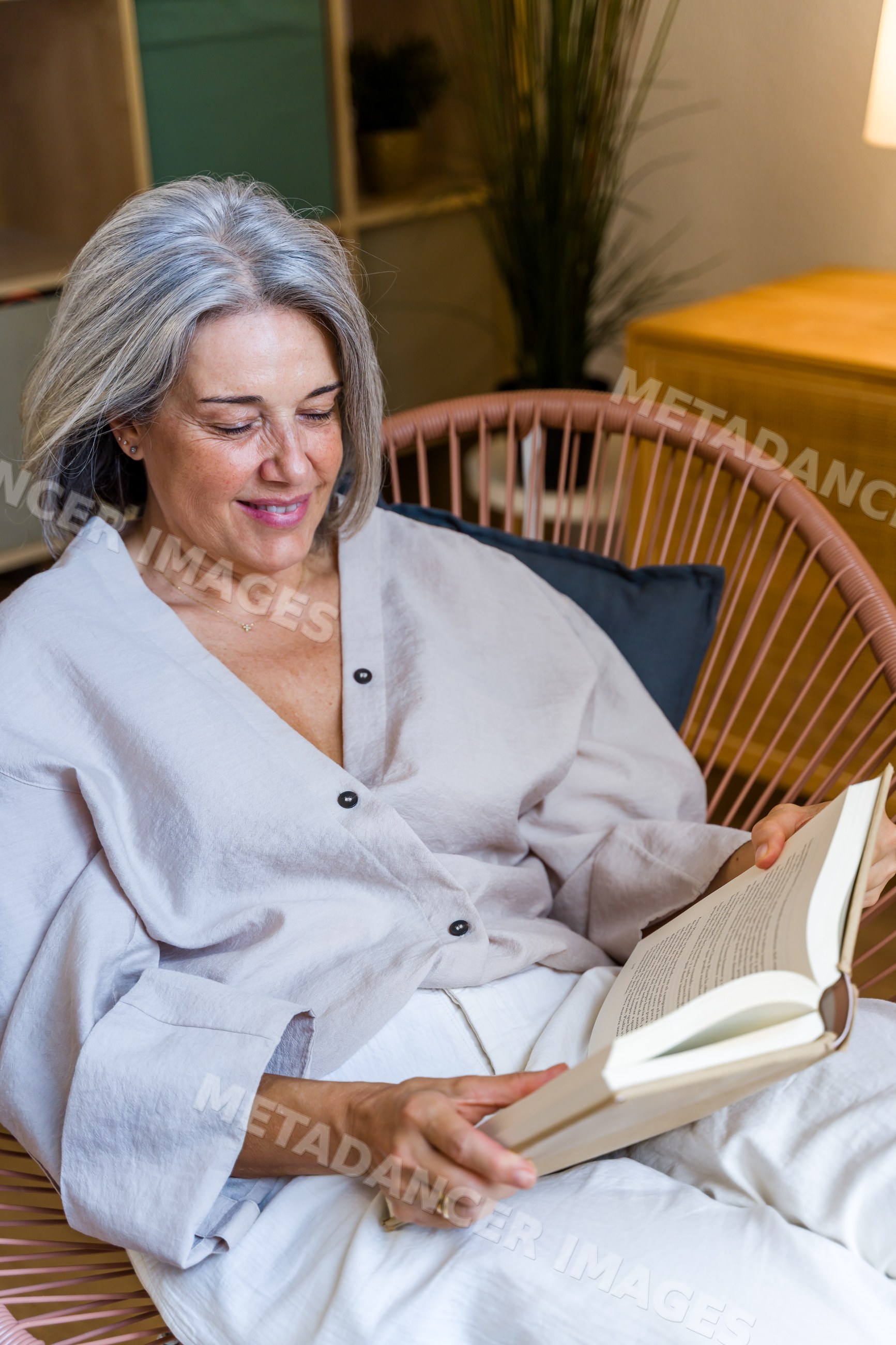 White woman reading book indoors in relaxed home setting in a home