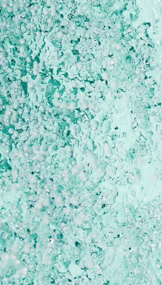 Close-up of vibrant aqua blue water splash with bubbles in motion