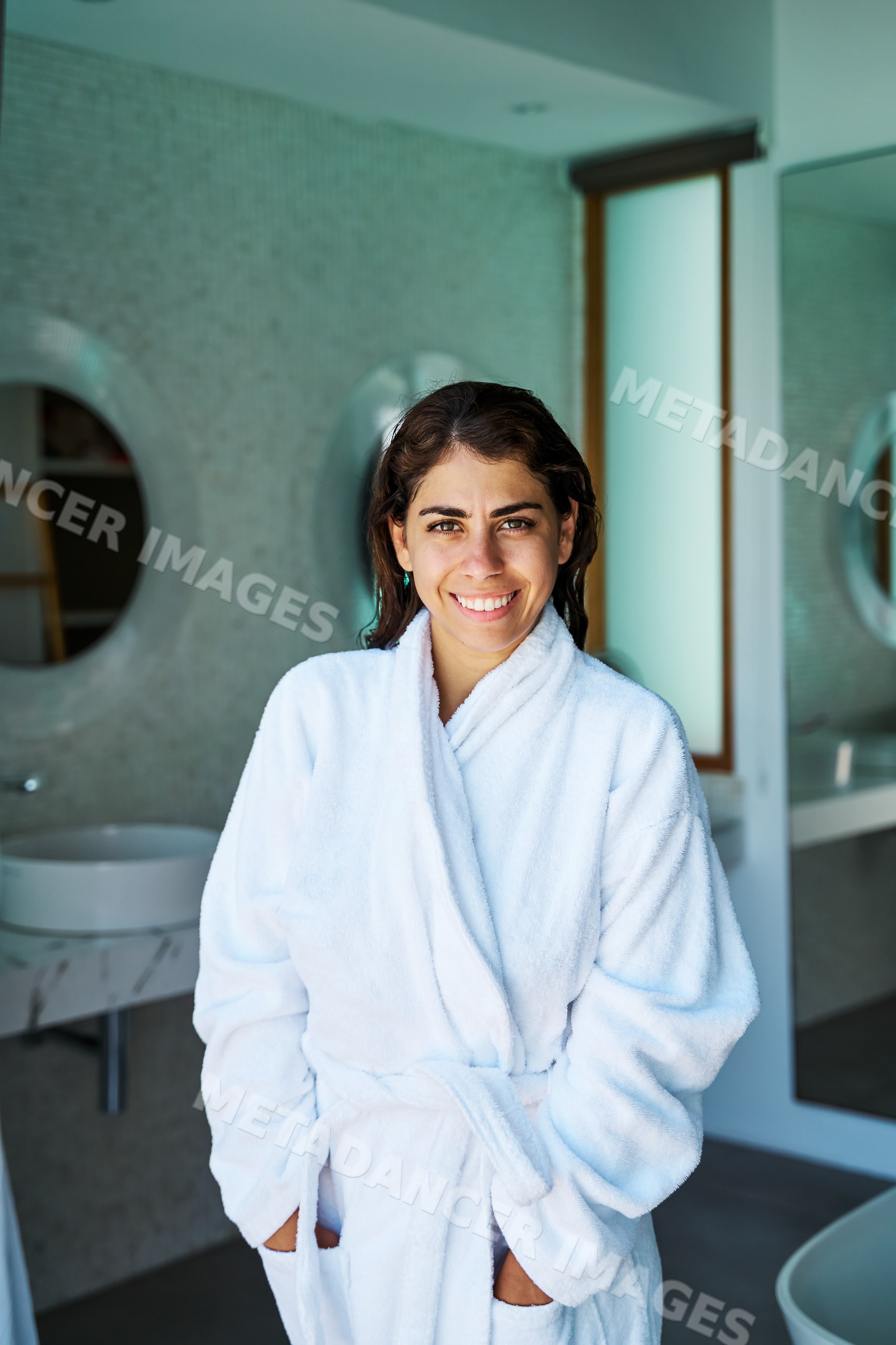 A smiling white woman enjoys relaxation in a modern bathroom