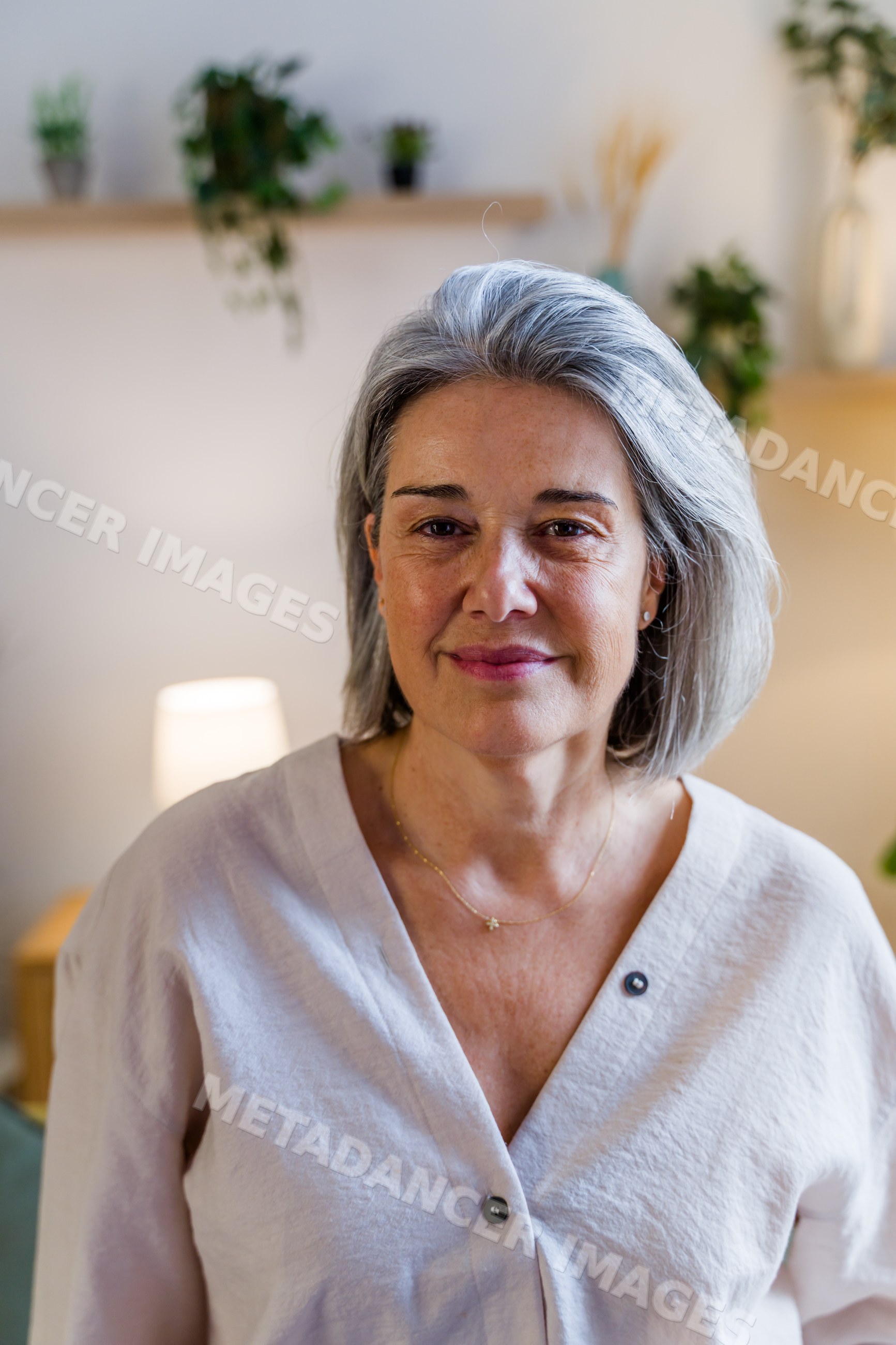 Middle-aged white woman with gray hair smiling indoors