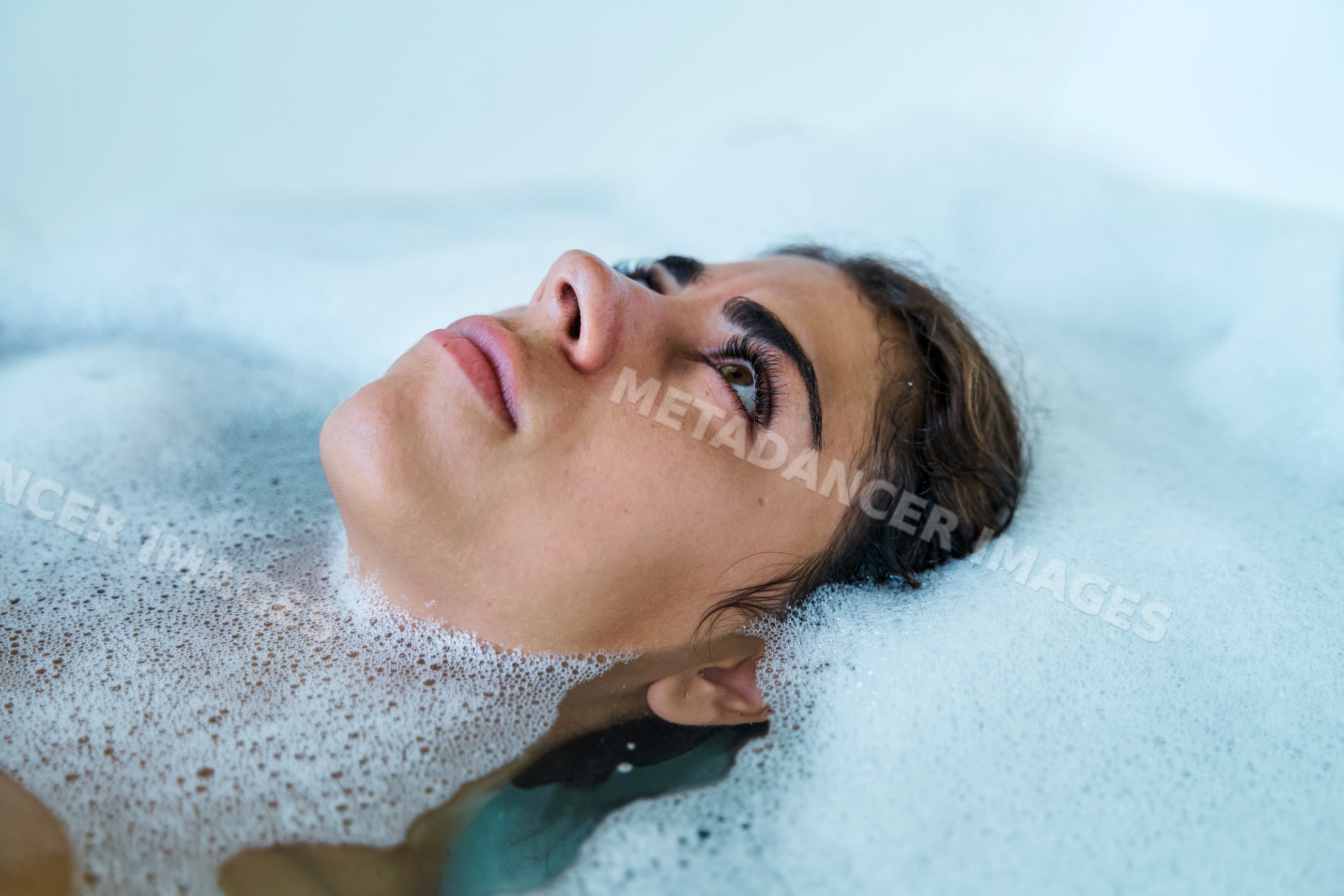 A white woman relaxes in a soothing bubble bath