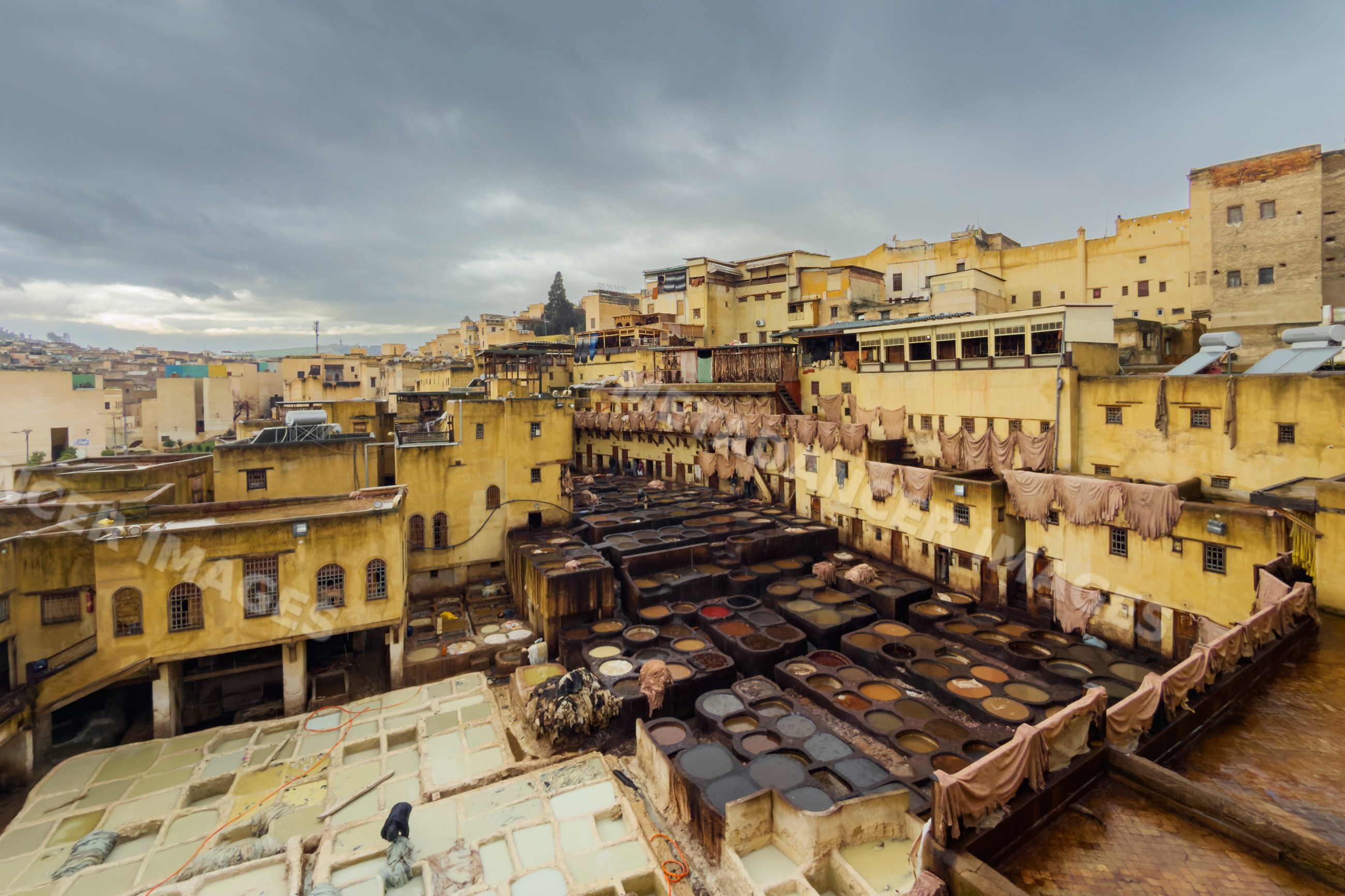 Chouara Tannery leather dyeing vats in fes Morocco under pouring rain
