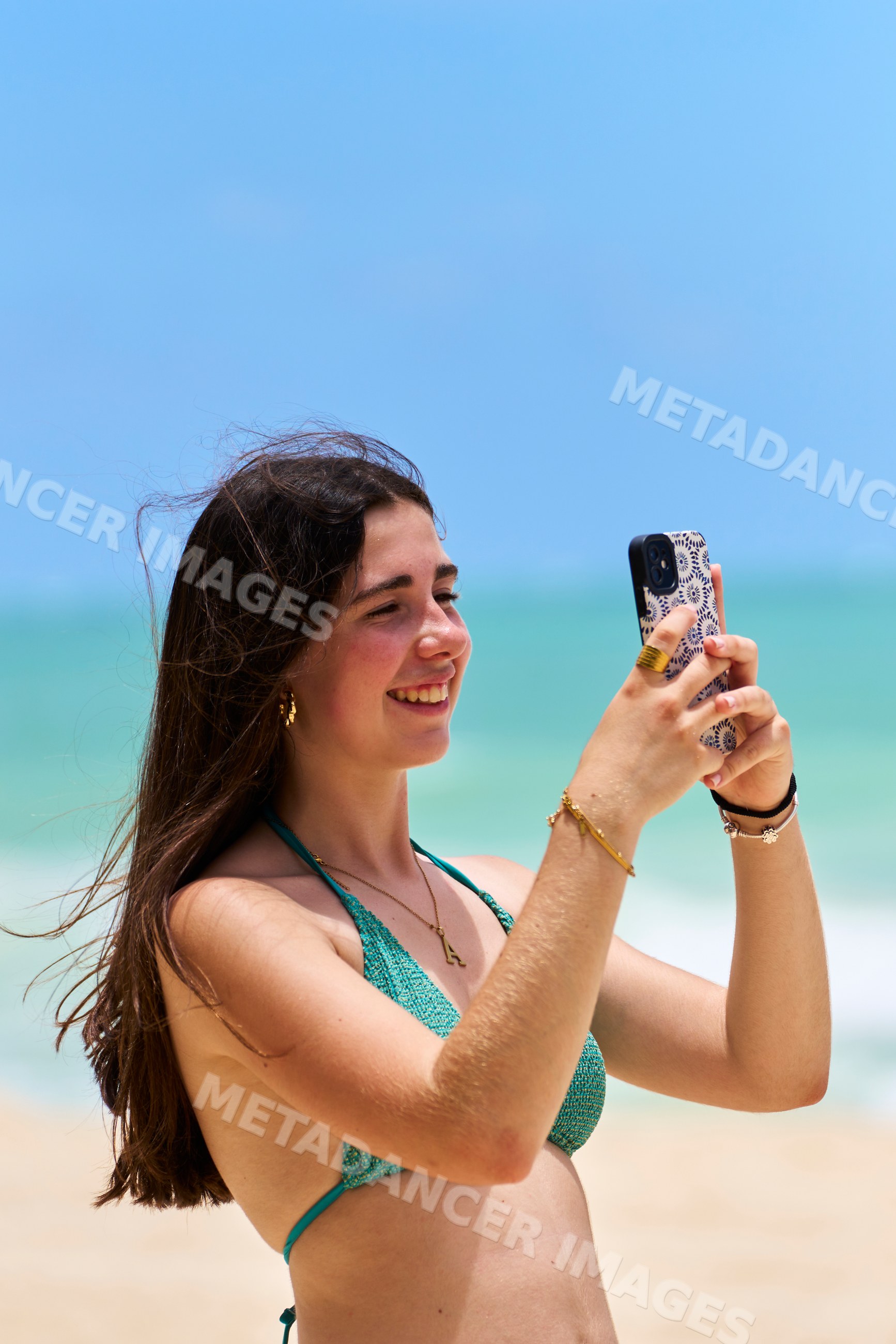 White woman taking photo with smartphone on beach in Hawaii, USA