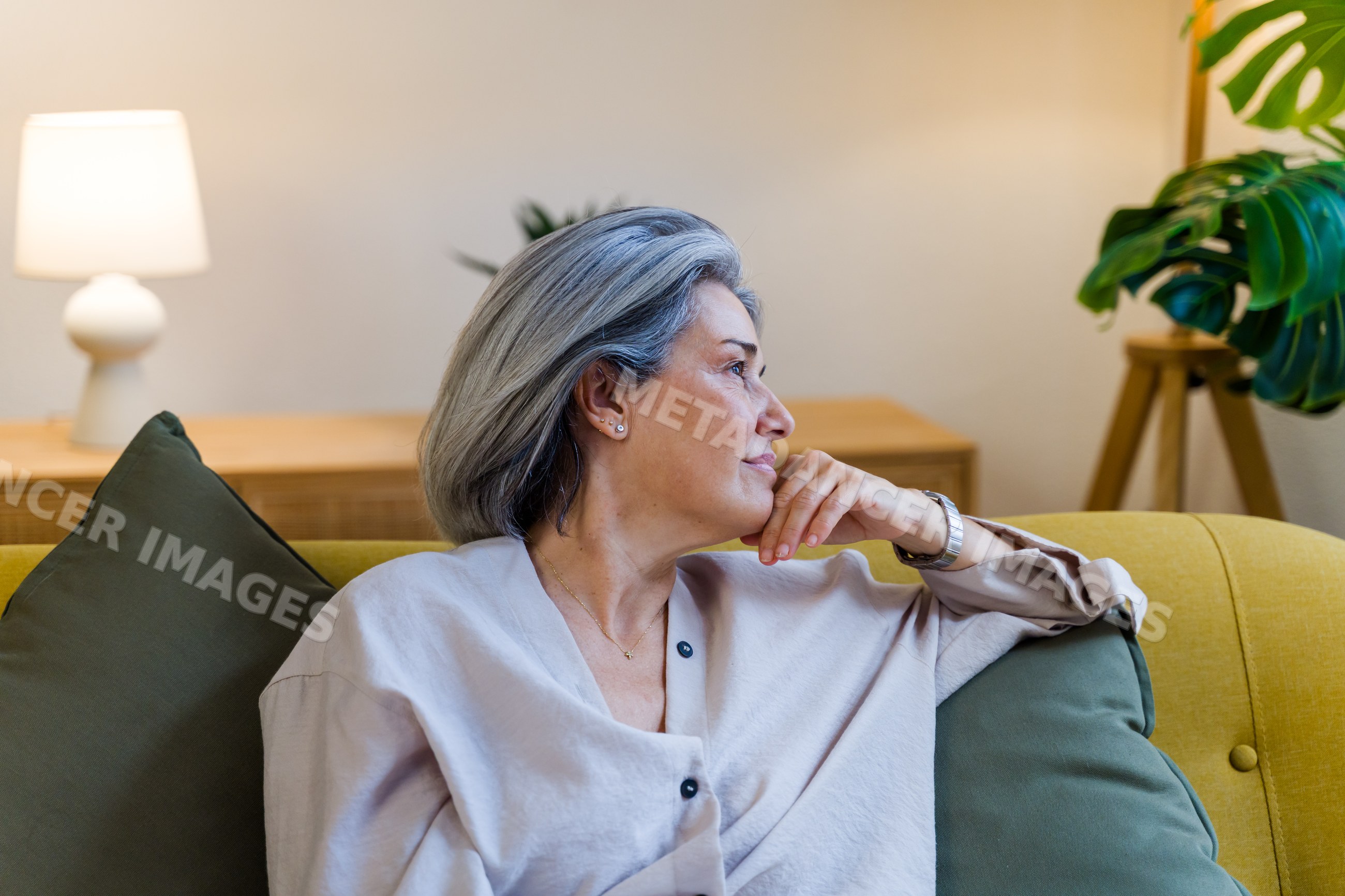 Mature white woman relaxing on sofa in cozy living room