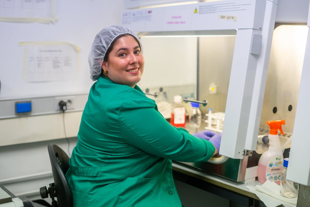 Hispanic woman working in biosafety cabinet in laboratory in Seville