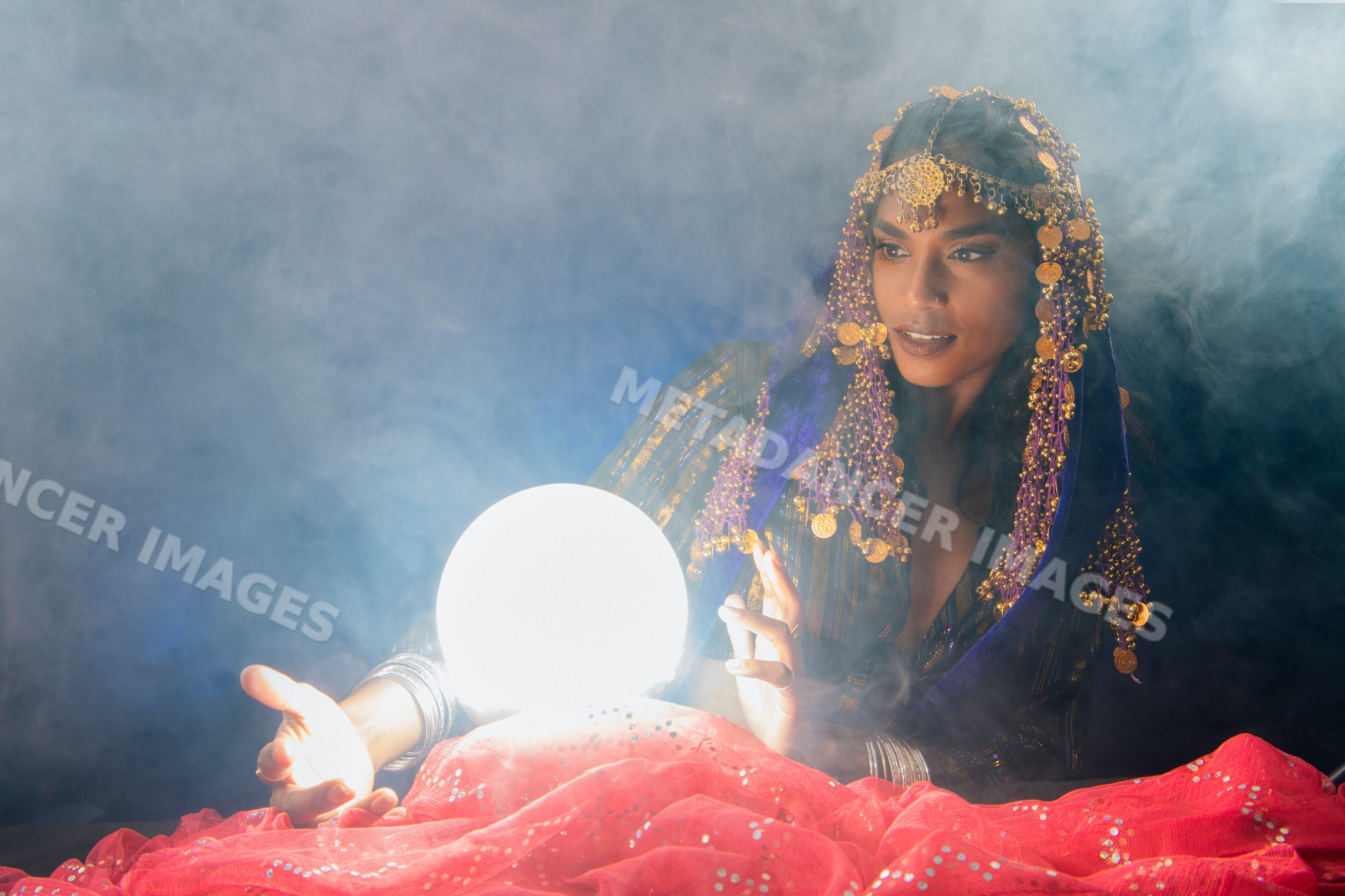 A fortune teller consults a glowing crystal ball surrounded by smoke