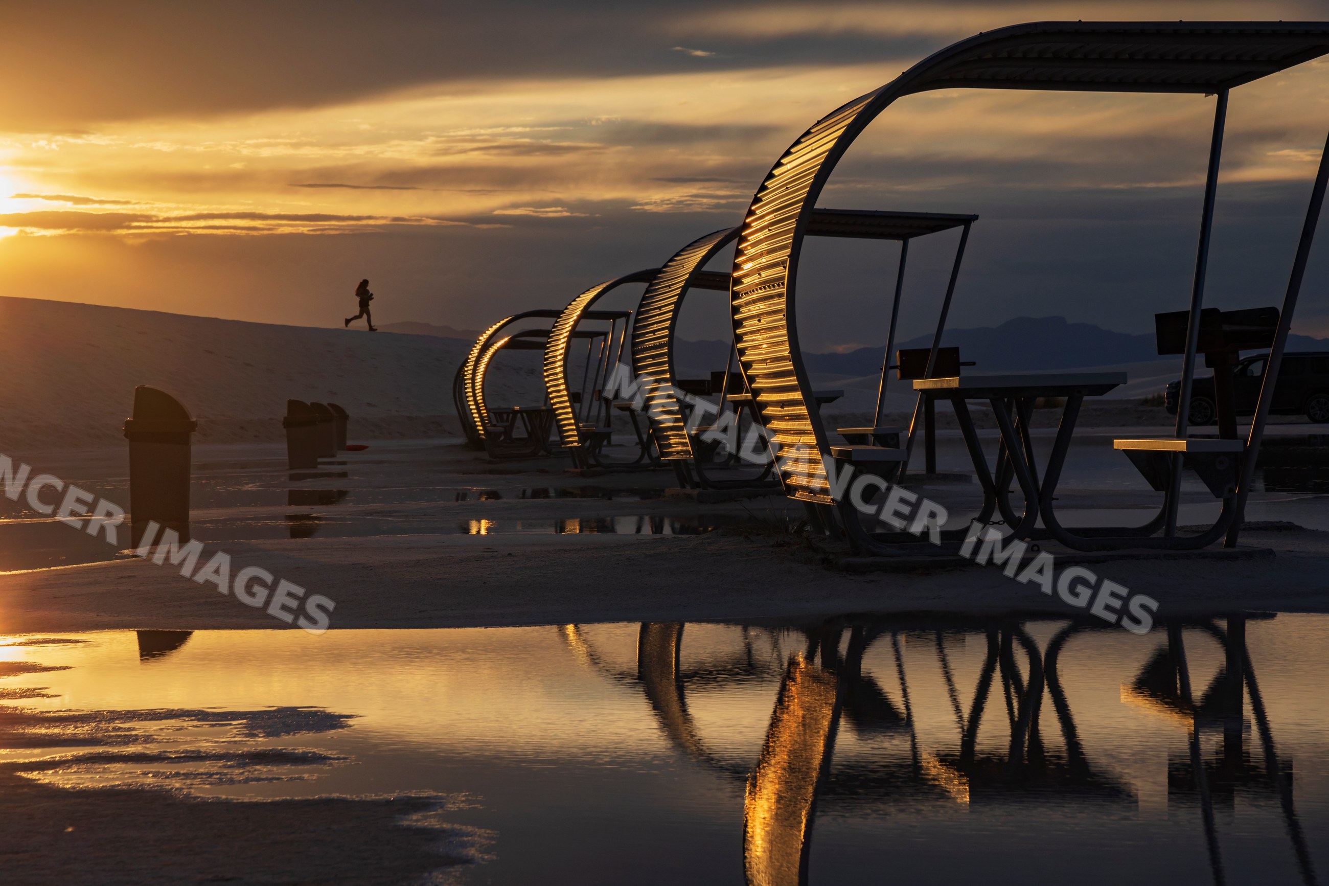Picnic shelters reflecting at Sunset with runner on sand dune