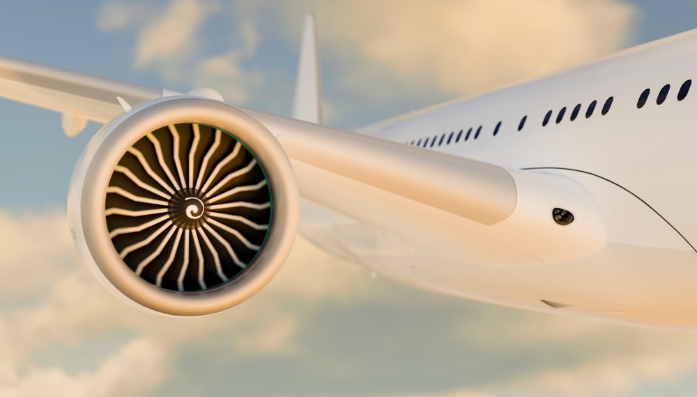 Close up of a jet engine on an airplane wing flying in the sky