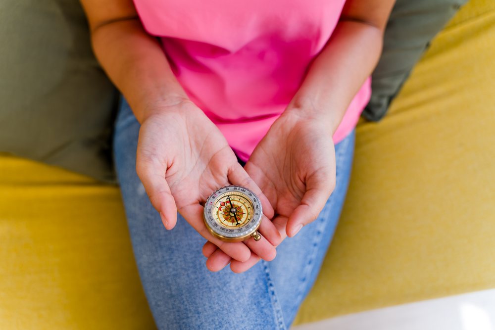 A Hispanic woman holds a compass
