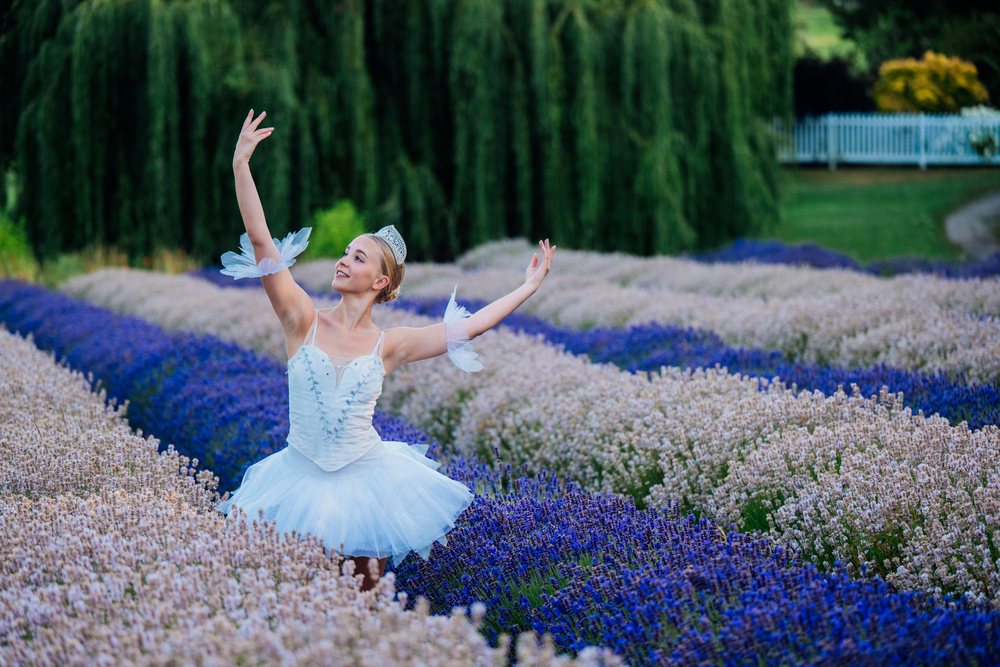 A ballerina gracefully dances outdoors in a lavender field