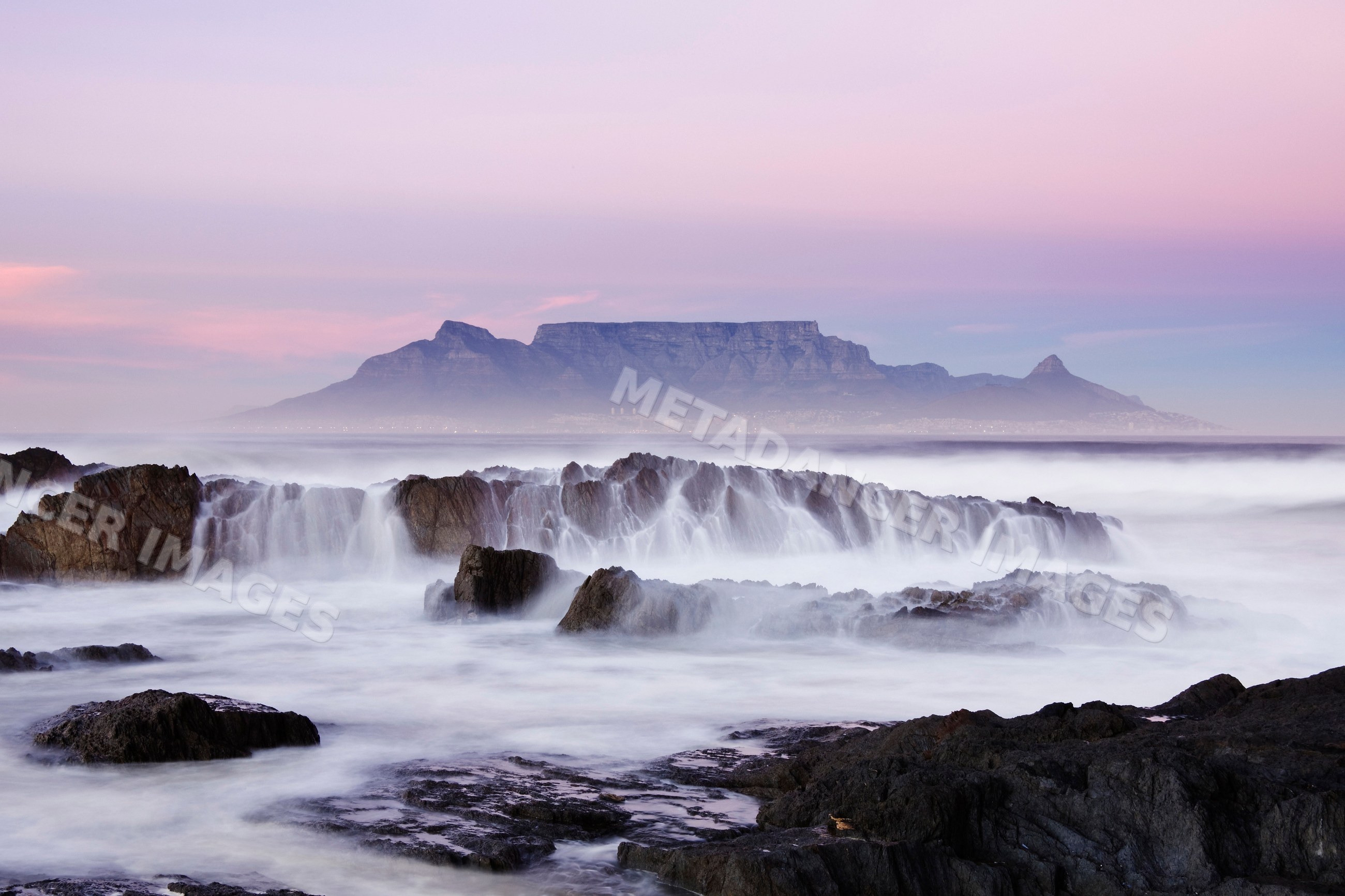 Table mountain and rocky coastline at sunset, south africa