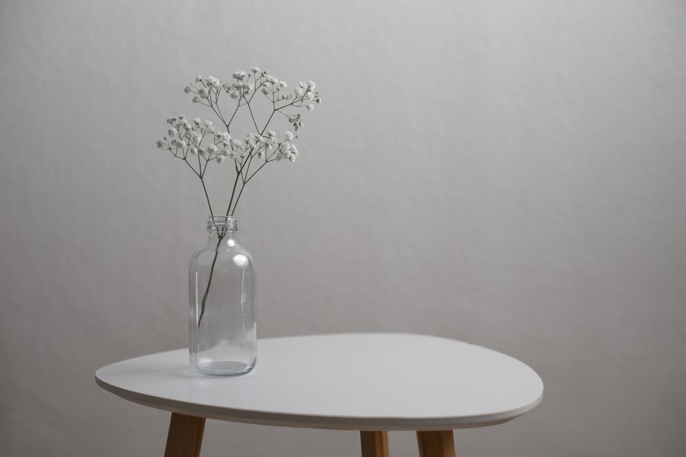 White flowers in glass bottle on modern minimalist table