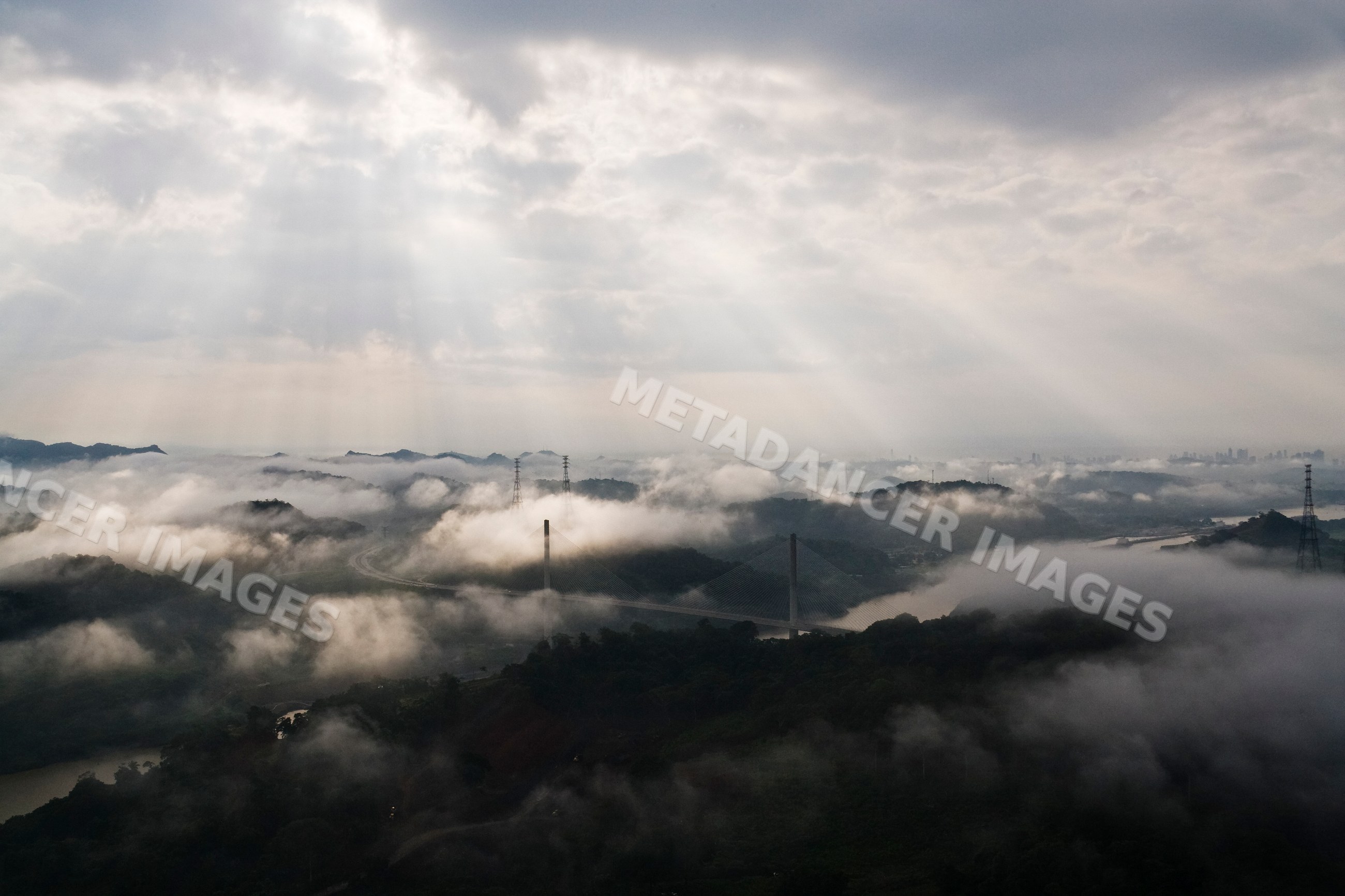 Centennial bridge spanning the panama canal with morning fog and sun