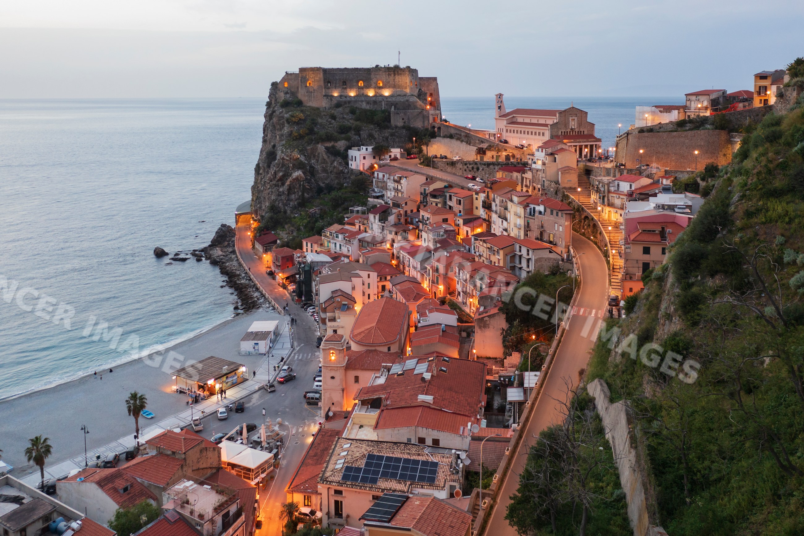 Scilla coastal town at dusk with historic fort and sea in calabria