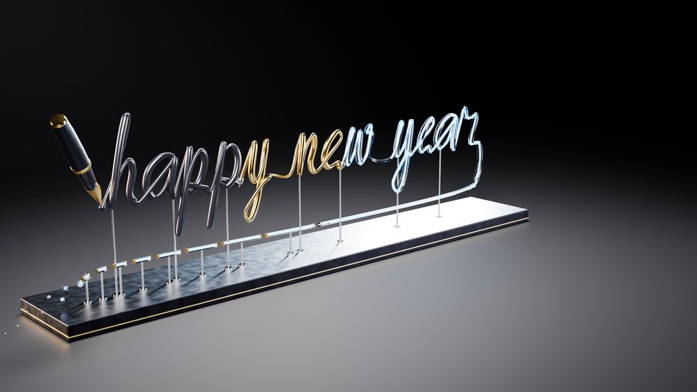 Metal sculpture of 'happy new year' text with pen on black background