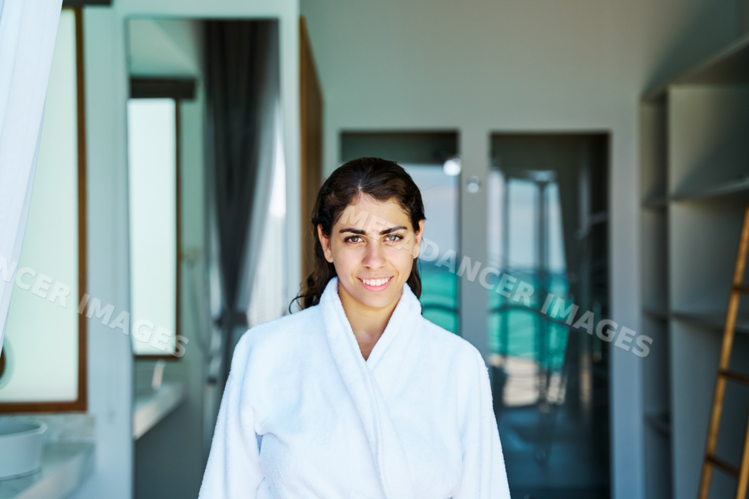 A white woman smiles inside a stylish hotel room in a hotel