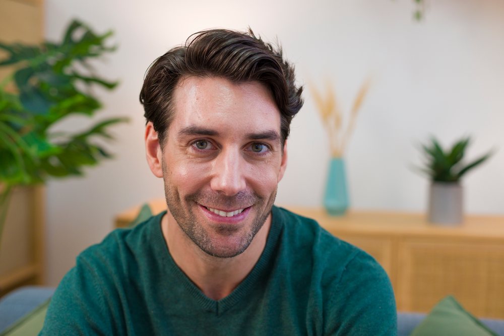 Smiling young white adult man sitting indoors