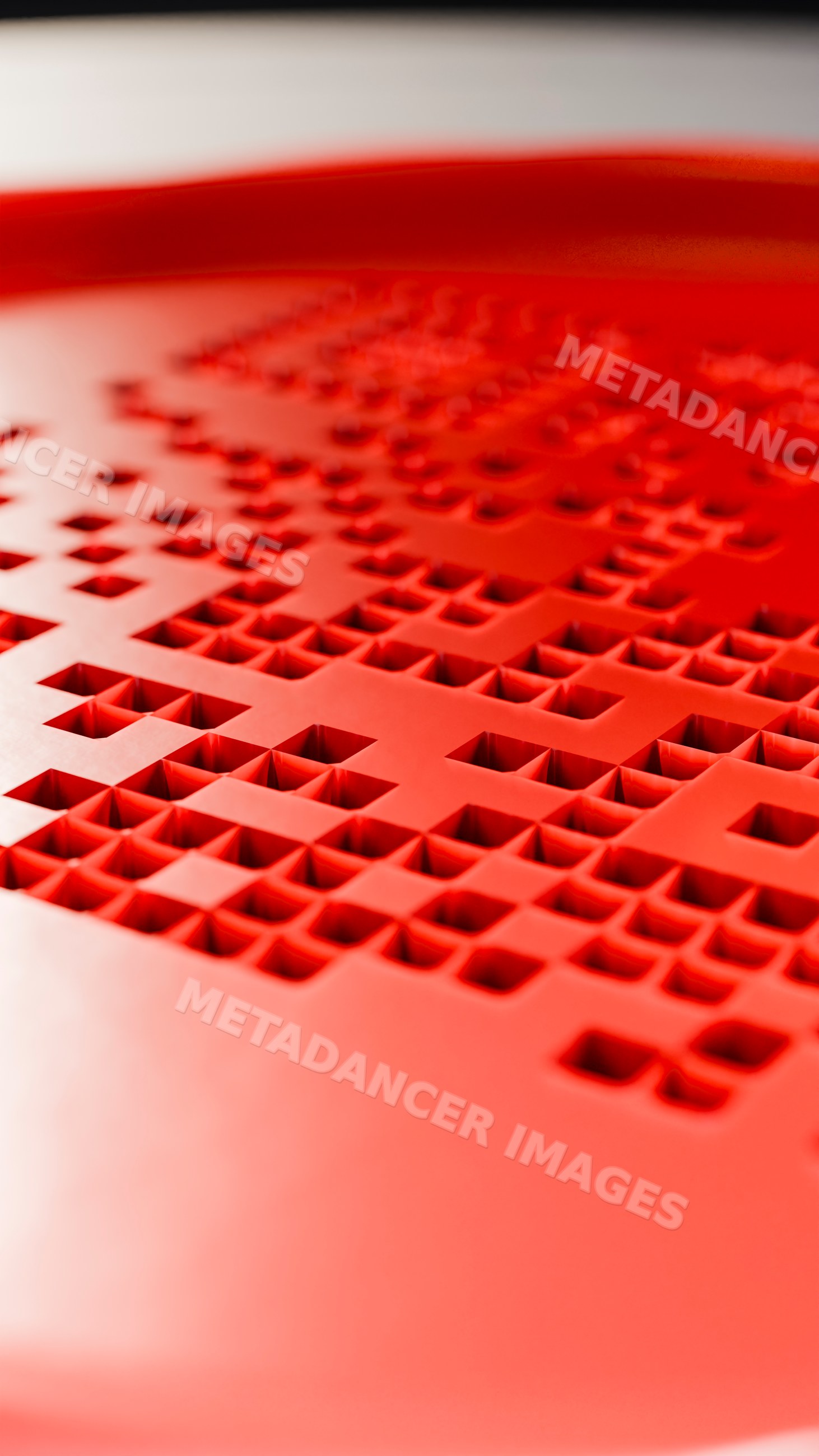 Red plastic surface with geometric square hole pattern